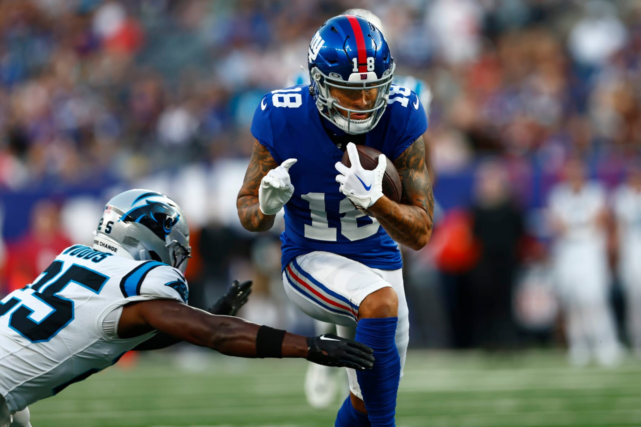 EAST RUTHERFORD, NEW JERSEY - AUGUST 18: Isaiah Hodgins #18 of the New York Giants in action against Xavier Woods #25 of the Carolina Panthers during a pre-season football game at MetLife Stadium on August 18, 2023 in East Rutherford, New Jersey. (Photo by Rich Schultz/Getty Images)