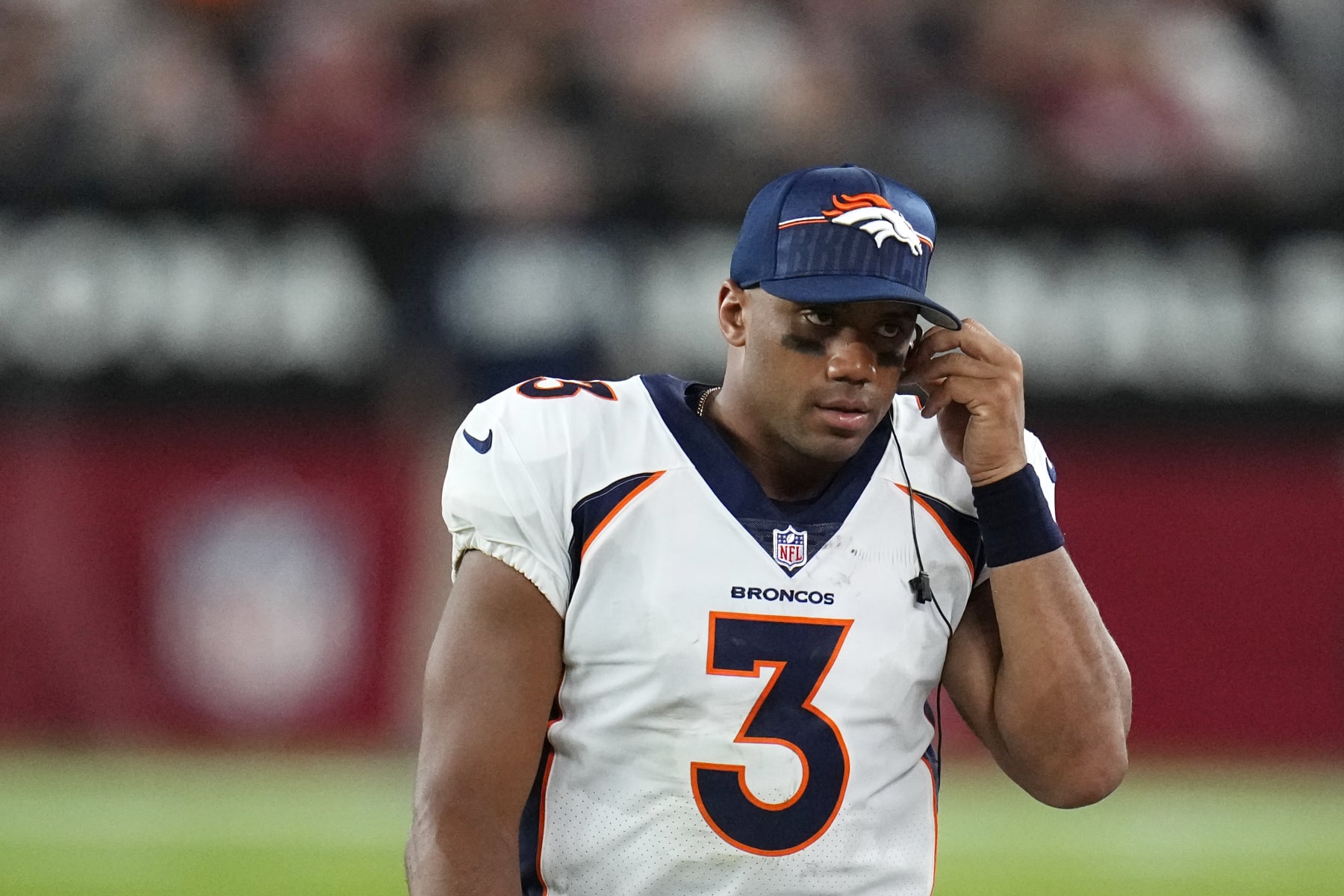 Denver Broncos quarterback Russell Wilson listens to play calling with an ear piece during the second half of an NFL preseason football game against the Arizona Cardinals, Friday, Aug. 11, 2023, in Glendale, Ariz. (AP Photo/Ross D. Franklin)