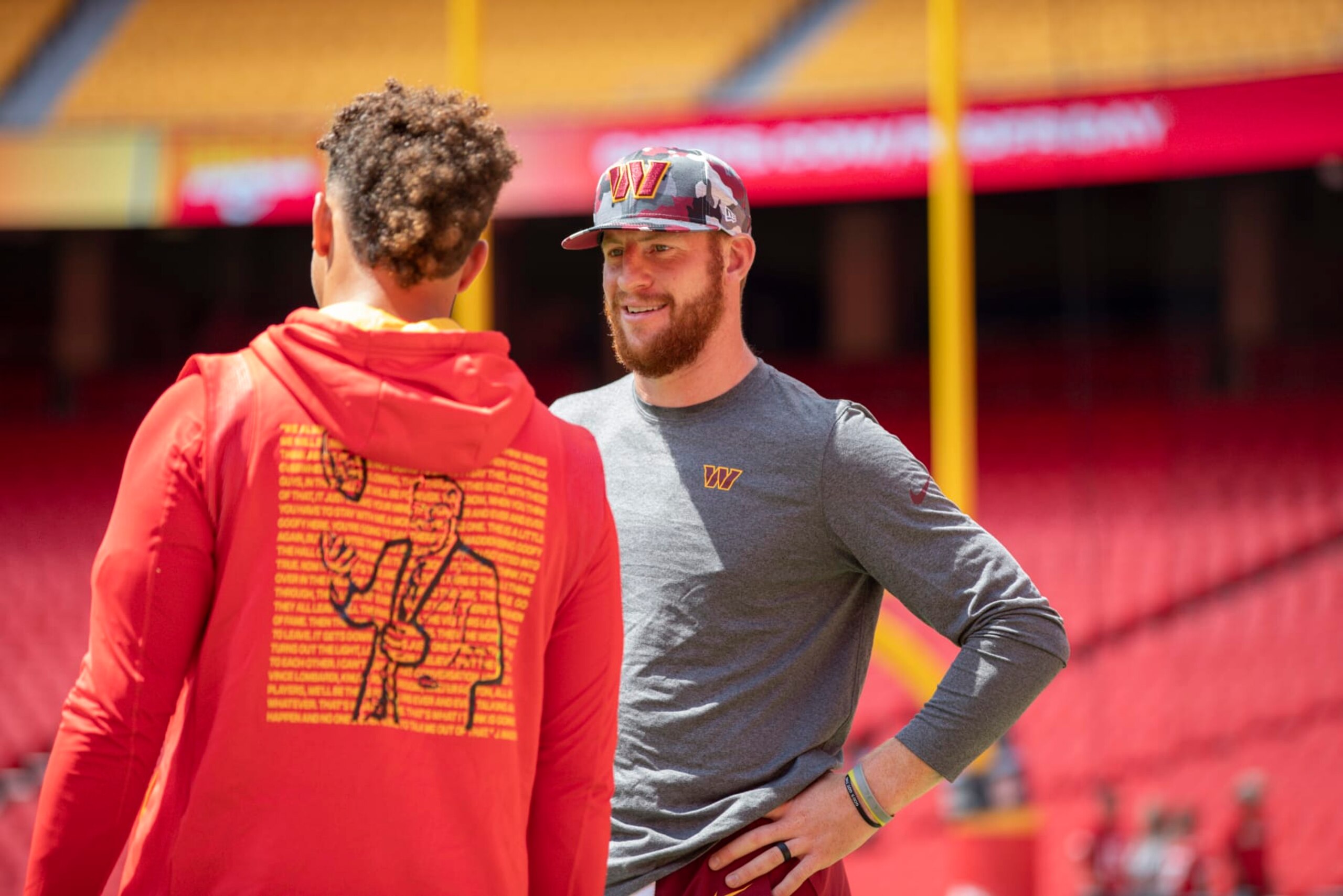 KANSAS CITY, MO - AUGUST 20: Carson Wentz #11 of the Washington Commanders speaks to Patrick Mahomes #15 of the Kansas City Chiefs prior to their preseason game at Arrowhead Stadium on August 20, 2022 in Kansas City, Missouri. (Photo by David Eulitt/Getty Images)