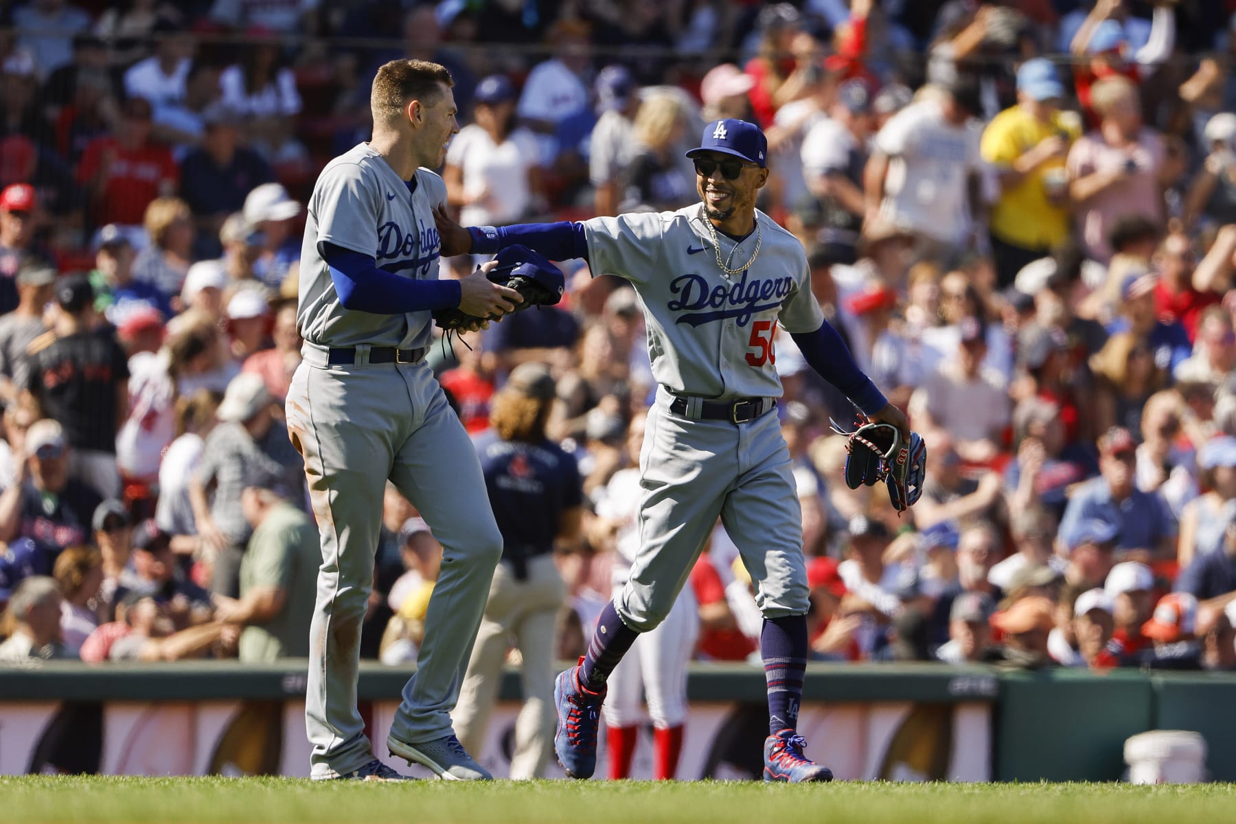 BOSTON, MA - AUGUST 27: Mookie Betts #50 of the Los Angeles Dodgers shares a laugh with teammate Freddie Freeman #5 while taking the field after he hit a two-run home run against the Boston Red Sox during the sixth inning at Fenway Park on August 27, 2023 in Boston, Massachusetts. (Photo By Winslow Townson/Getty Images)