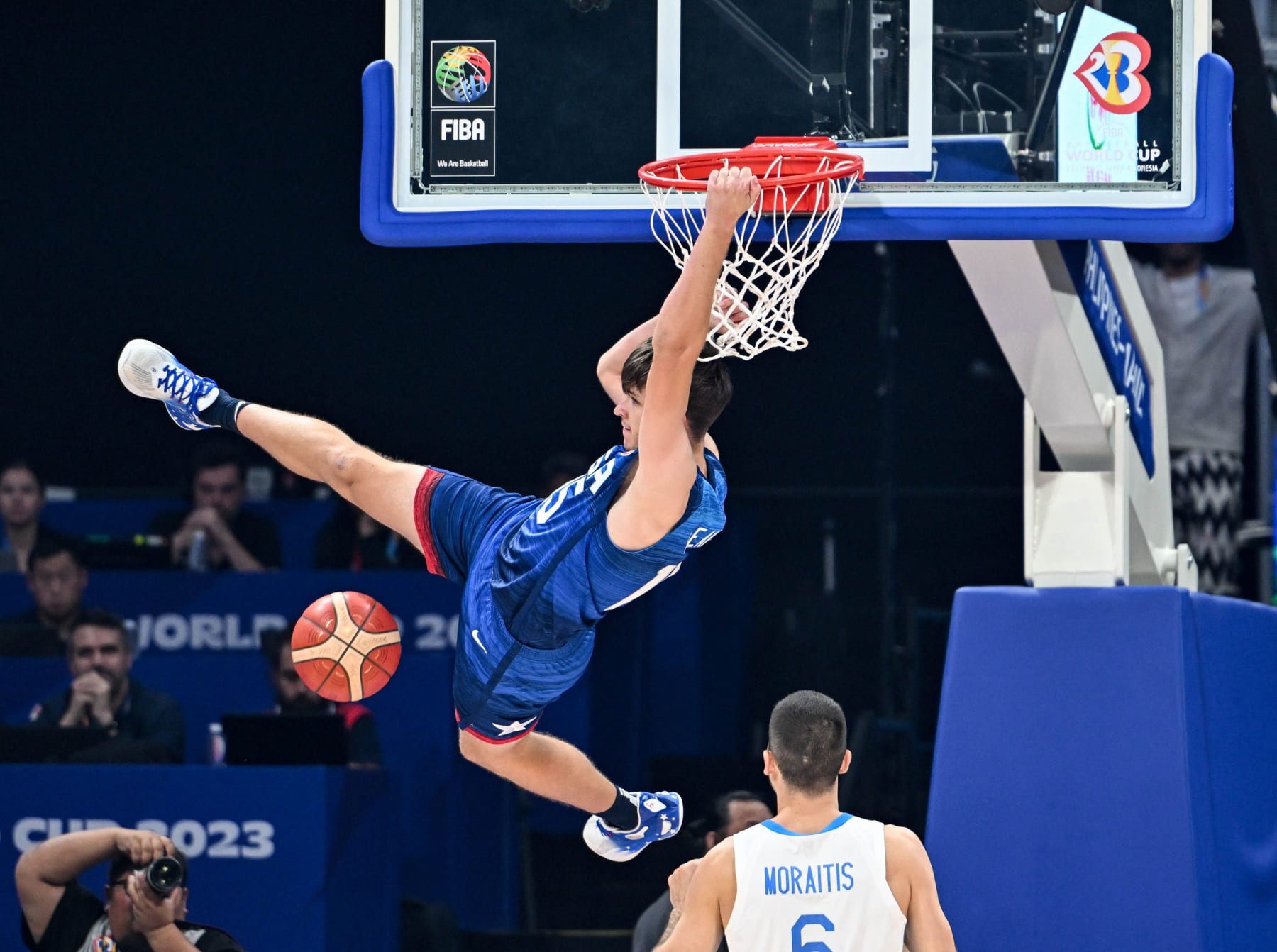 US' Austin Reaves (L) hangs onto the basket during the FIBA Basketball World Cup group C match between US and Greece  at the Mall of Asia Arena in Pasay city, suburban Manila on August 28, 2023. (Photo by SHERWIN VARDELEON / AFP) (Photo by SHERWIN VARDELEON/AFP via Getty Images)