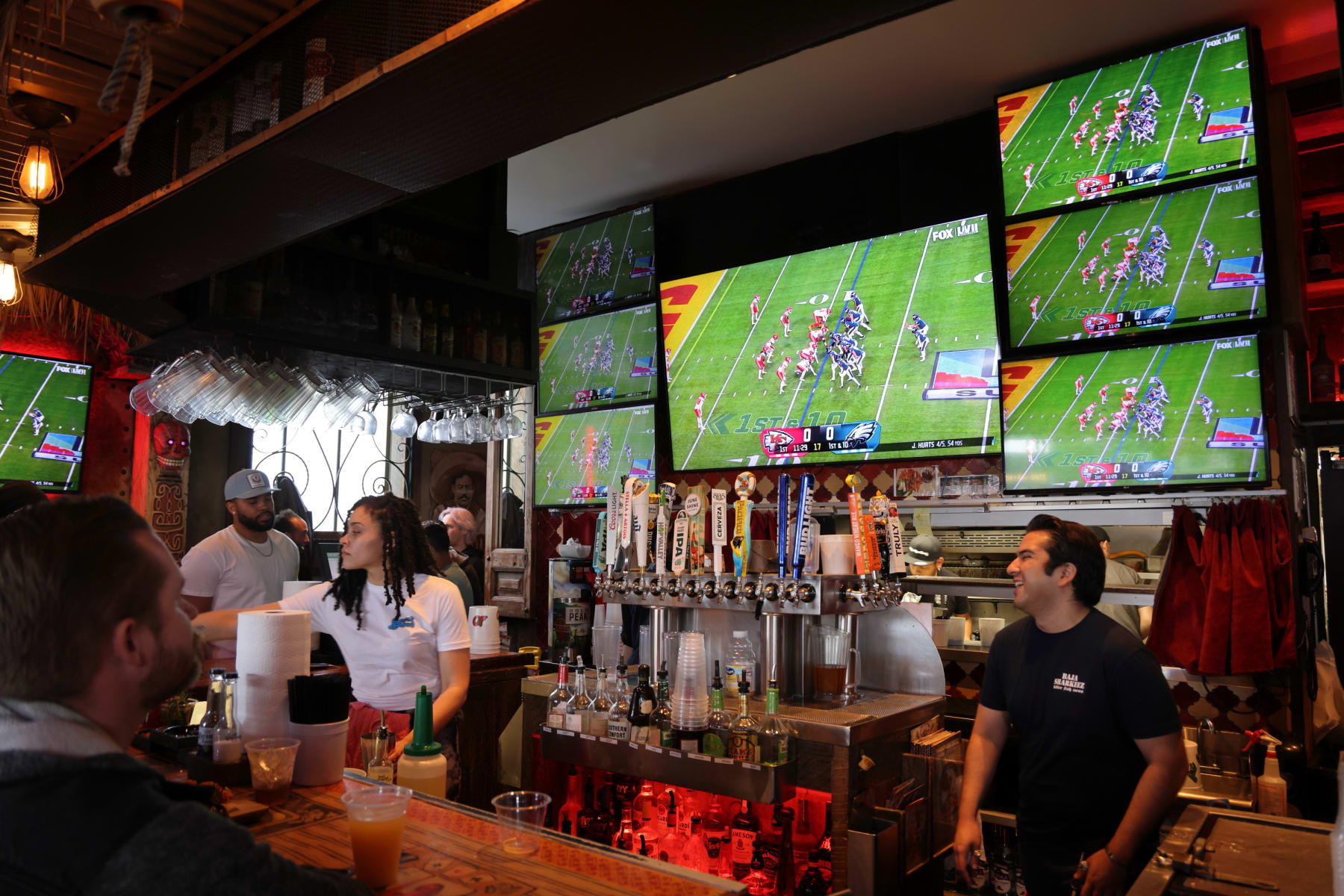 NEWPORT BEACH, CALIFORNIA - FEBRUARY 12: People watch Super Bowl LVII between the Philadelphia Eagles and the Kansas City Chiefs on televisions at a bar on February 12, 2023 in Newport Beach, California. (Photo by I RYU/VCG via Getty Images)