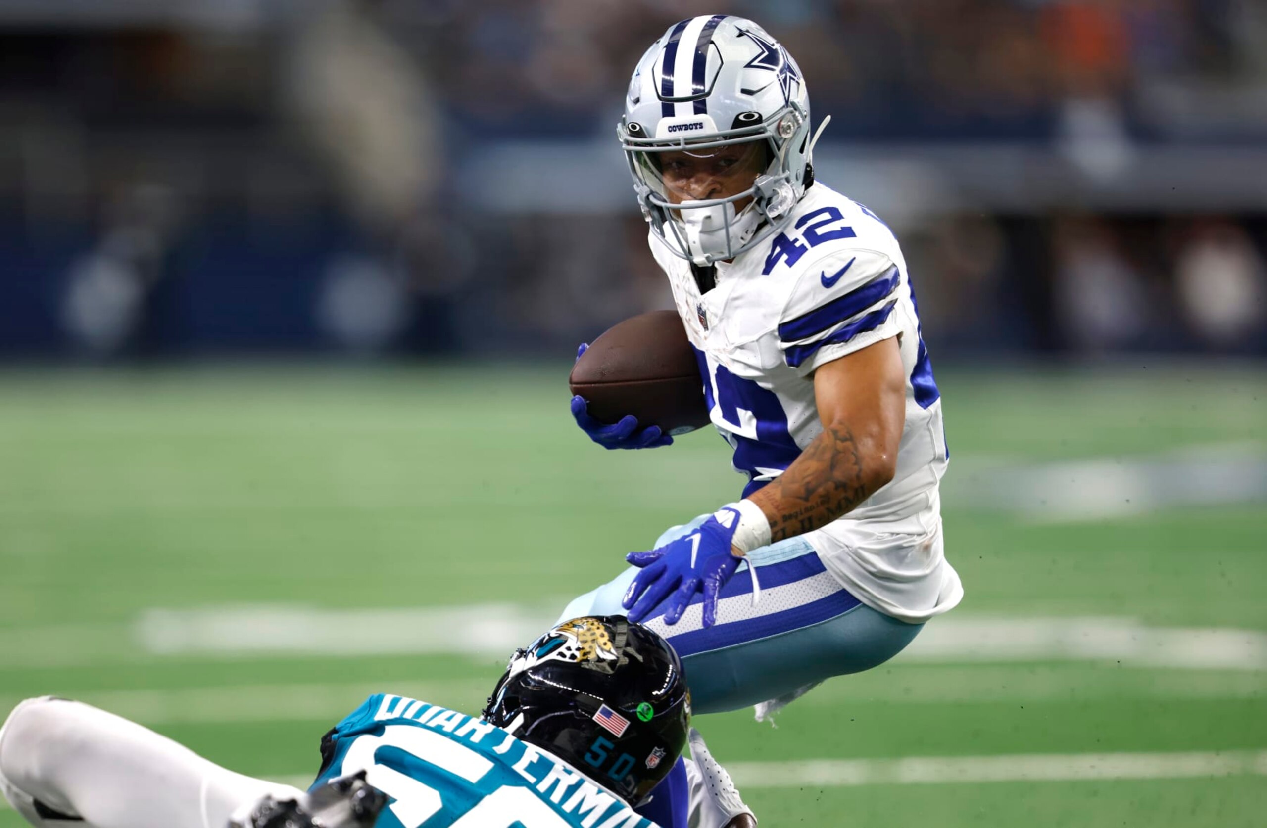 ARLINGTON, TX - AUGUST 12: Deuce Vaughn #42 of the Dallas Cowboys tries to evade Shaquille Quarterman #50 of the Jacksonville Jaguars during the second half of a preseason game at AT&T Stadium on August 12, 2023 in Arlington, Texas. (Photo by Ron Jenkins/Getty Images)