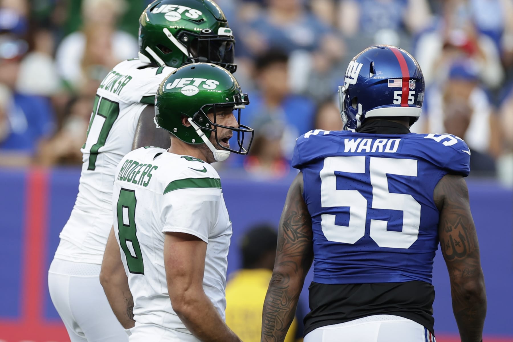 New York Jets quarterback Aaron Rodgers (8) and New York Giants linebacker Jihad Ward (55) exchange words during the first half of an NFL preseason football game, Saturday, Aug. 26, 2023, in East Rutherford, N.J. (AP Photo/Adam Hunger)