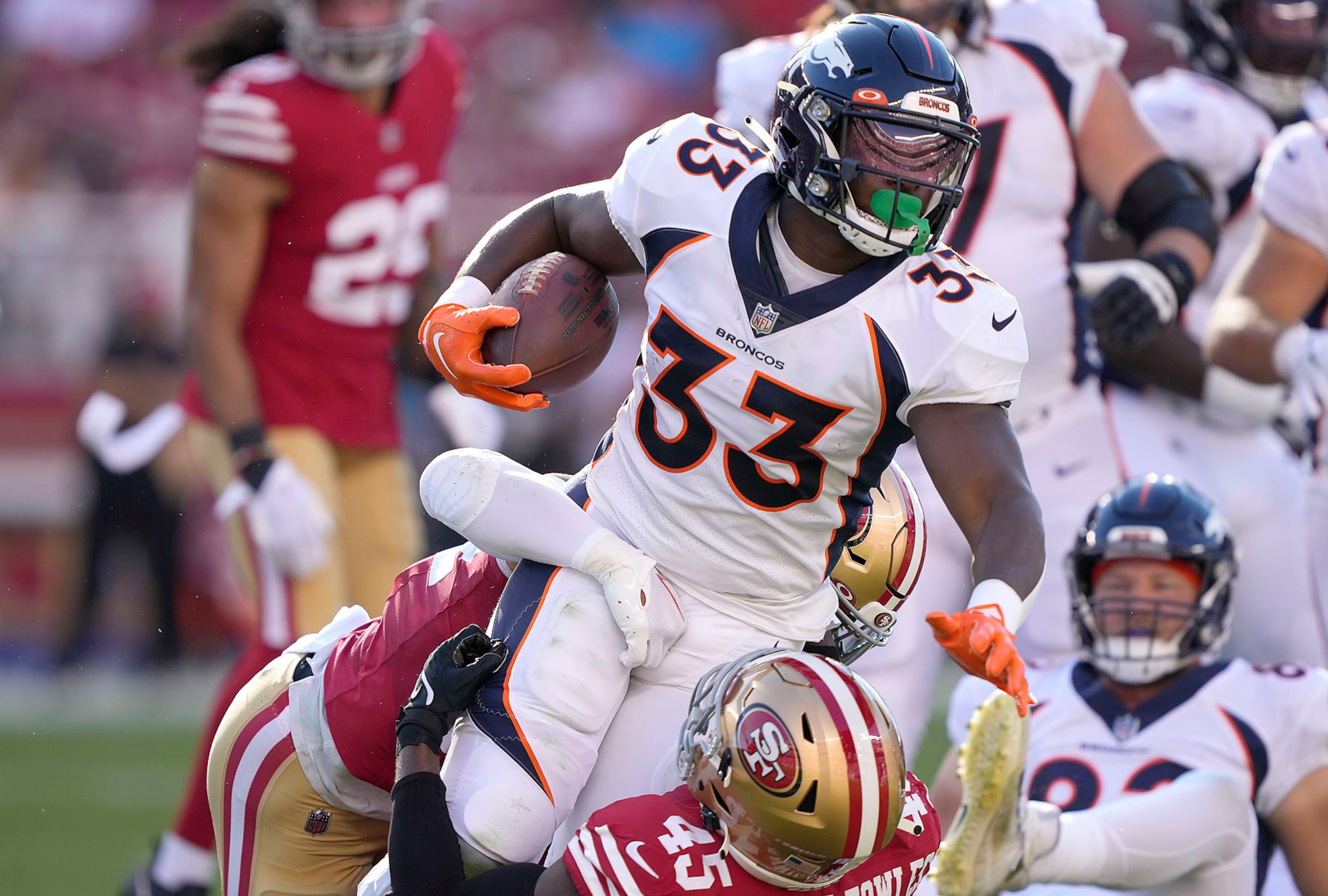 SANTA CLARA, CALIFORNIA - AUGUST Javonte Williams #33 of the Denver Broncos gets tackled by Demetrius Flannigan-Fowles #45 of the San Francisco 49ers during the first quarter of a preseason game  at Levi's Stadium on August 19, 2023 in Santa Clara, California. (Photo by Thearon W. Henderson/Getty Images)