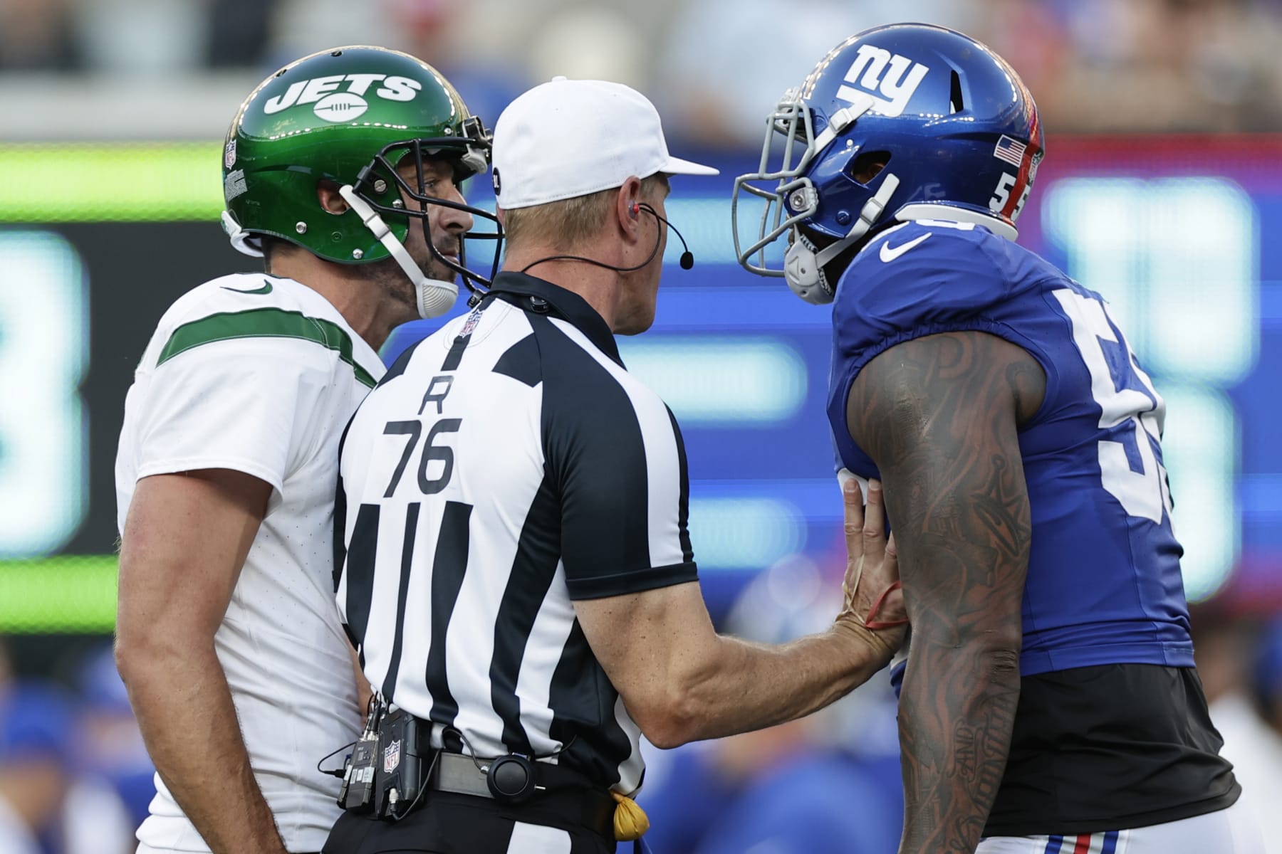 New York Jets quarterback Aaron Rodgers (8) and New York Giants linebacker Jihad Ward (55) exchange words during the first half of an NFL preseason football game, Saturday, Aug. 26, 2023, in East Rutherford, N.J. (AP Photo/Adam Hunger)