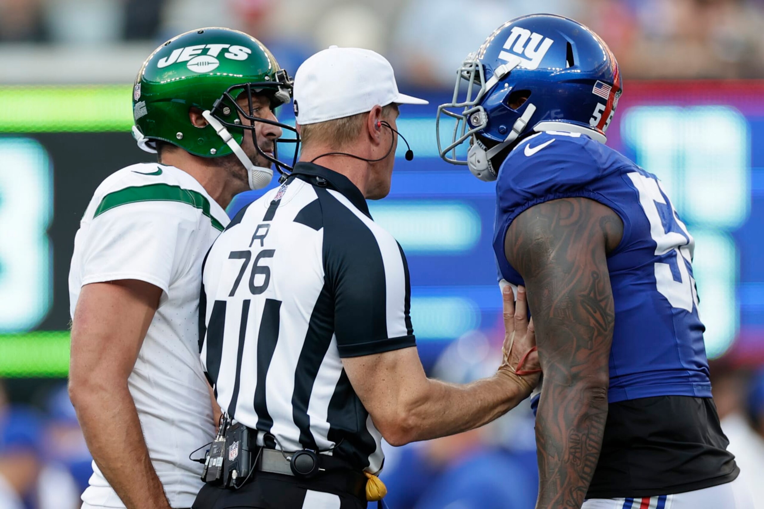 New York Jets quarterback Aaron Rodgers (8) and New York Giants linebacker Jihad Ward (55) exchange words during the first half of an NFL preseason football game, Saturday, Aug. 26, 2023, in East Rutherford, N.J. (AP Photo/Adam Hunger)