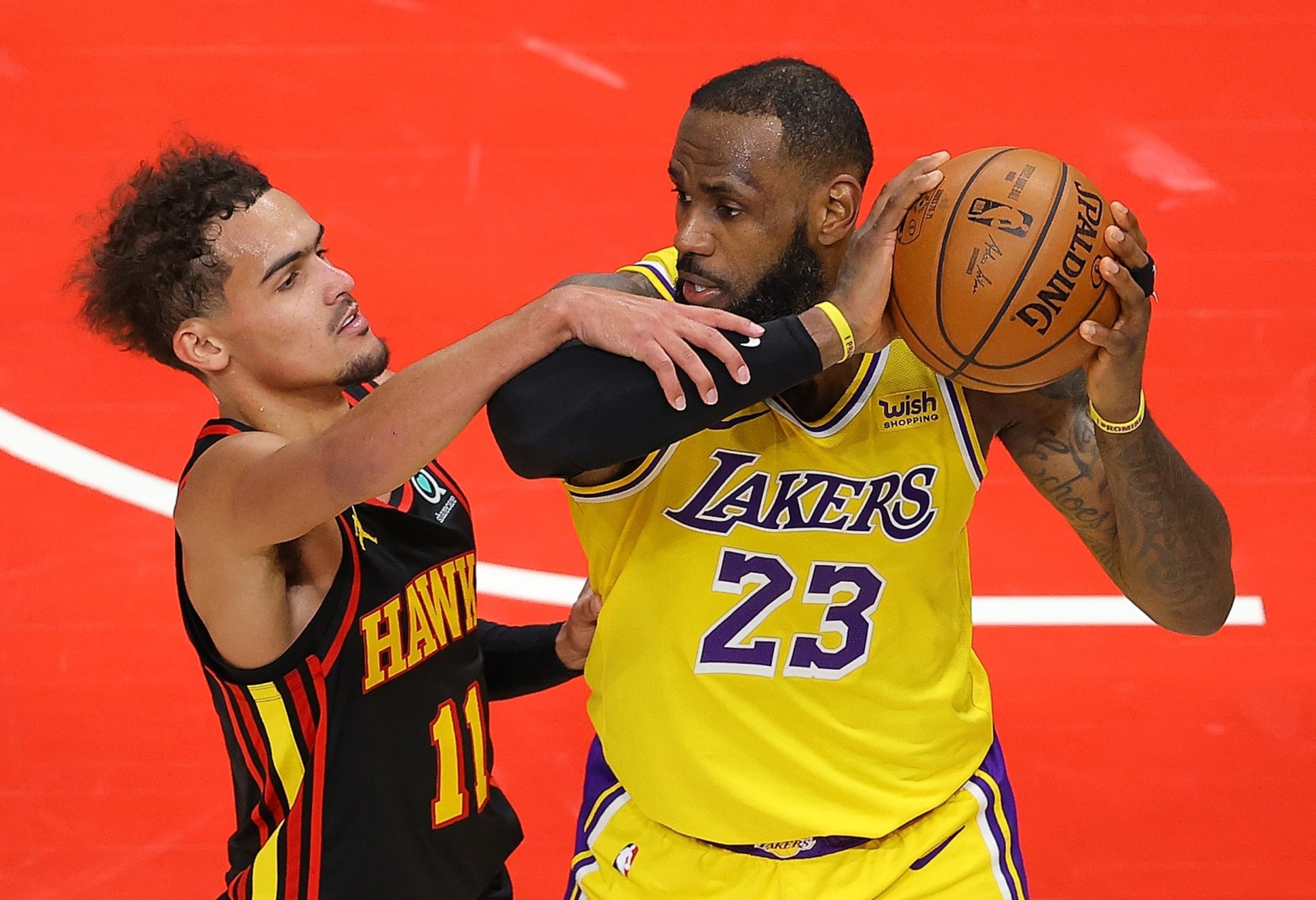 ATLANTA, GEORGIA - FEBRUARY 01:   Trae Young #11 of the Atlanta Hawks fouls LeBron James #23 of the Los Angeles Lakers in the finals seconds of the second half at State Farm Arena on February 01, 2021 in Atlanta, Georgia.  NOTE TO USER: User expressly acknowledges and agrees that, by downloading and or using this photograph, User is consenting to the terms and conditions of the Getty Images License Agreement.  (Photo by Kevin C. Cox/Getty Images)