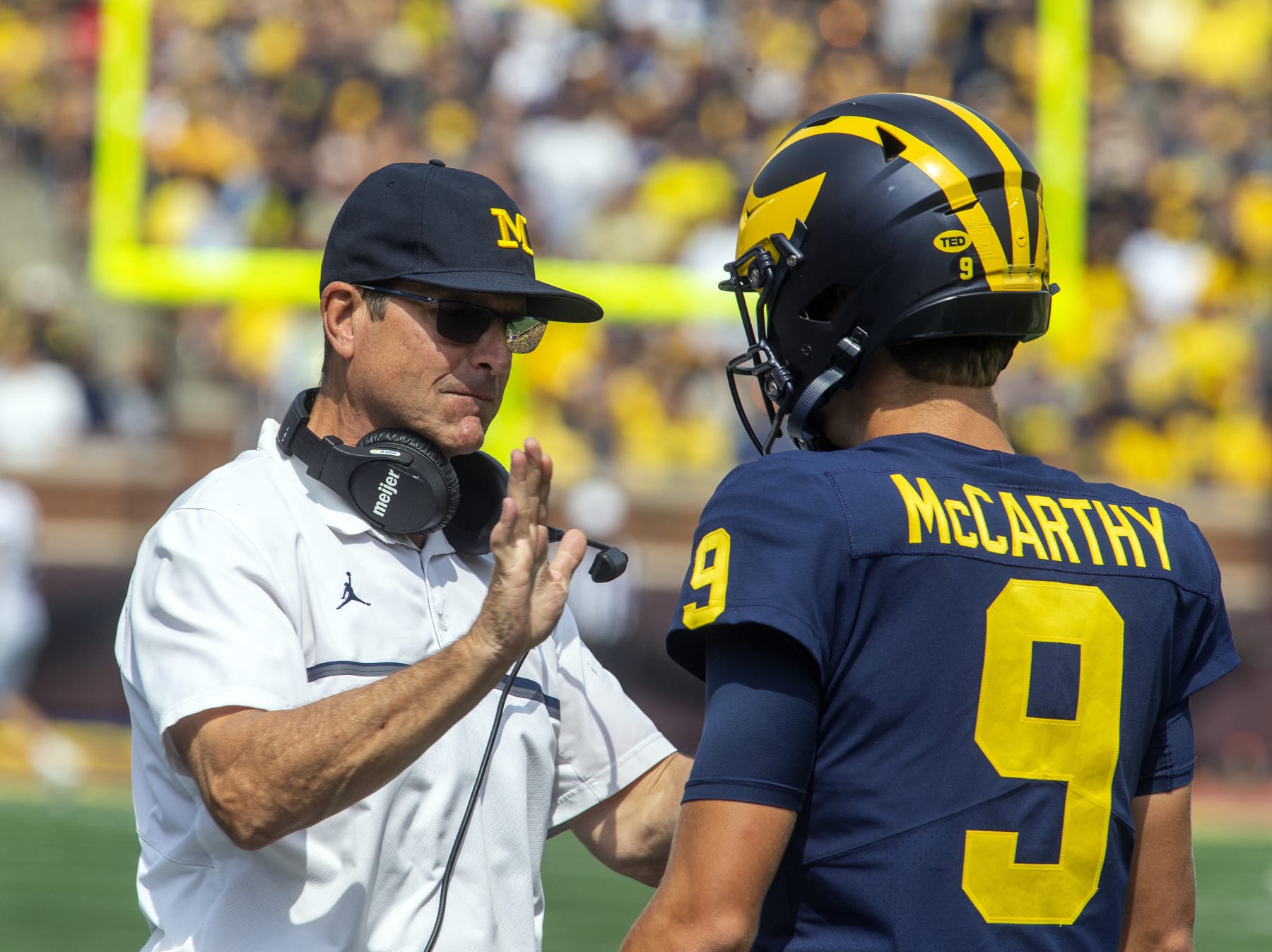 Michigan head coach Jim Harbaugh gives encouragement to quarterback J.J. McCarthy (9) before the true freshman takes his first career snap in the third quarter of an NCAA college football game against Western Michigan in Ann Arbor, Mich., Saturday, Sept. 4, 2021. Michigan won 47-14. (AP Photo/Tony Ding)