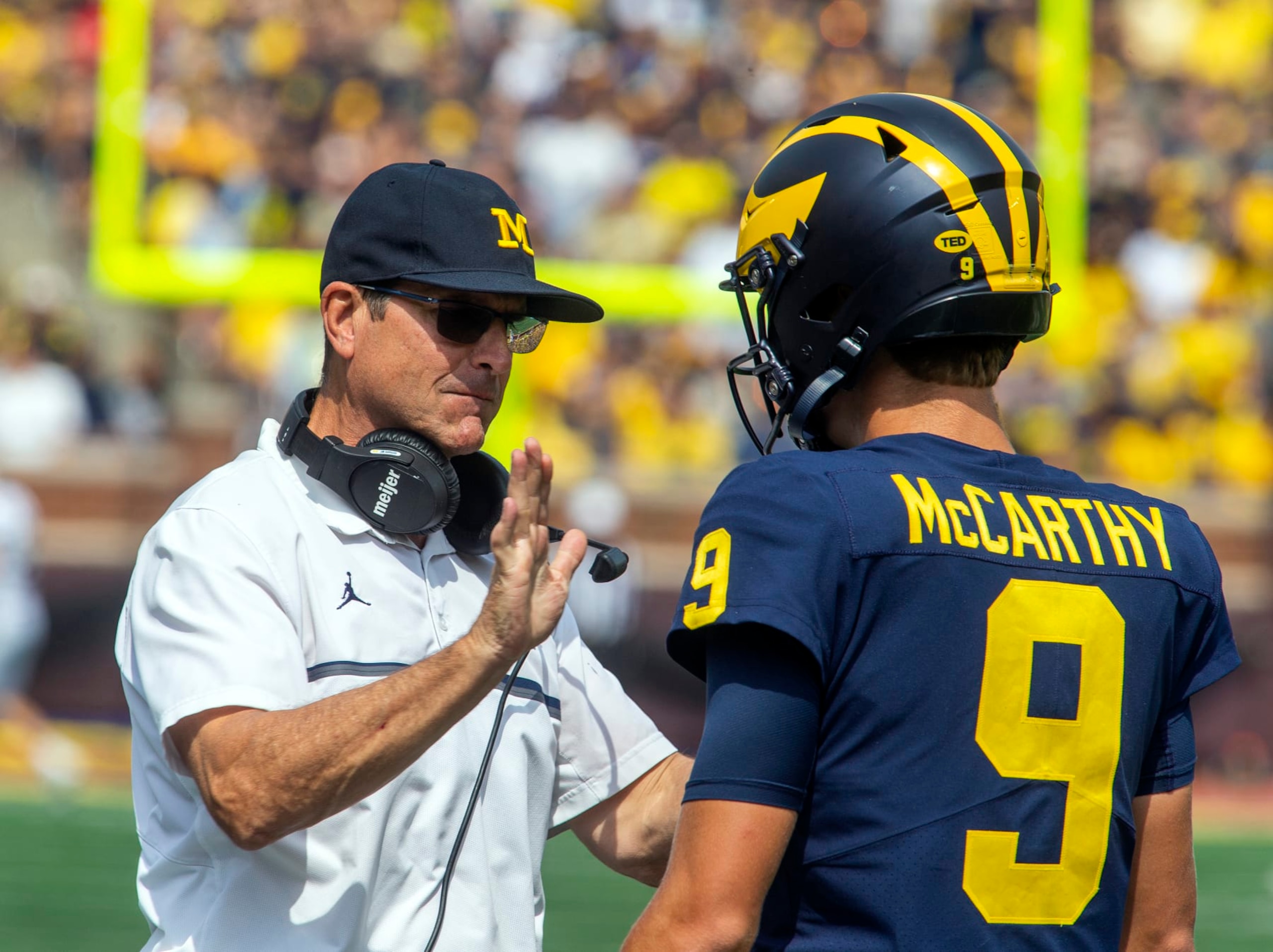Michigan head coach Jim Harbaugh gives encouragement to quarterback J.J. McCarthy (9) before the true freshman takes his first career snap in the third quarter of an NCAA college football game against Western Michigan in Ann Arbor, Mich., Saturday, Sept. 4, 2021. Michigan won 47-14. (AP Photo/Tony Ding)
