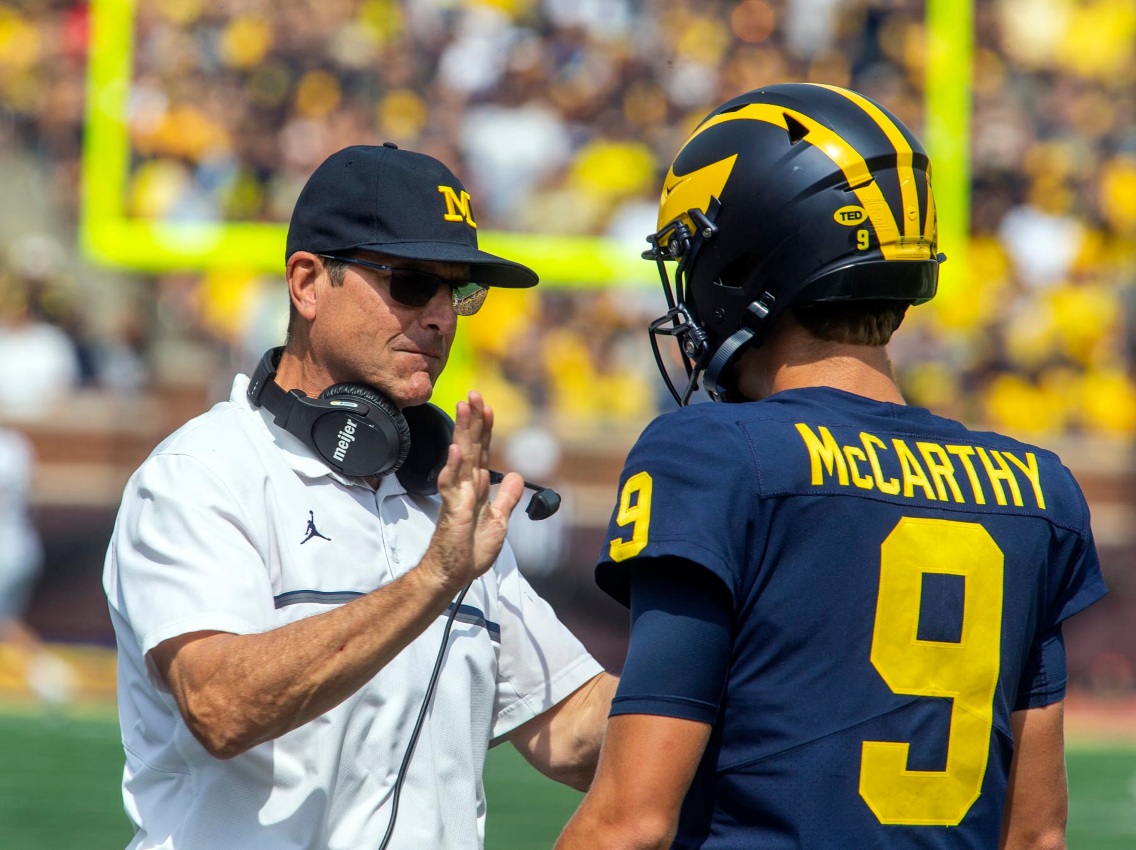 Michigan head coach Jim Harbaugh gives encouragement to quarterback J.J. McCarthy (9) before the true freshman takes his first career snap in the third quarter of an NCAA college football game against Western Michigan in Ann Arbor, Mich., Saturday, Sept. 4, 2021. Michigan won 47-14. (AP Photo/Tony Ding) Michigan head coach Jim Harbaugh gives encouragement to quarterback J.J. McCarthy (9) before the true freshman takes his first career snap in the third quarter of an NCAA college football game against Western Michigan in Ann Arbor, Mich., Saturday, Sept. 4, 2021. Michigan won 47-14. (AP Photo/Tony Ding)
