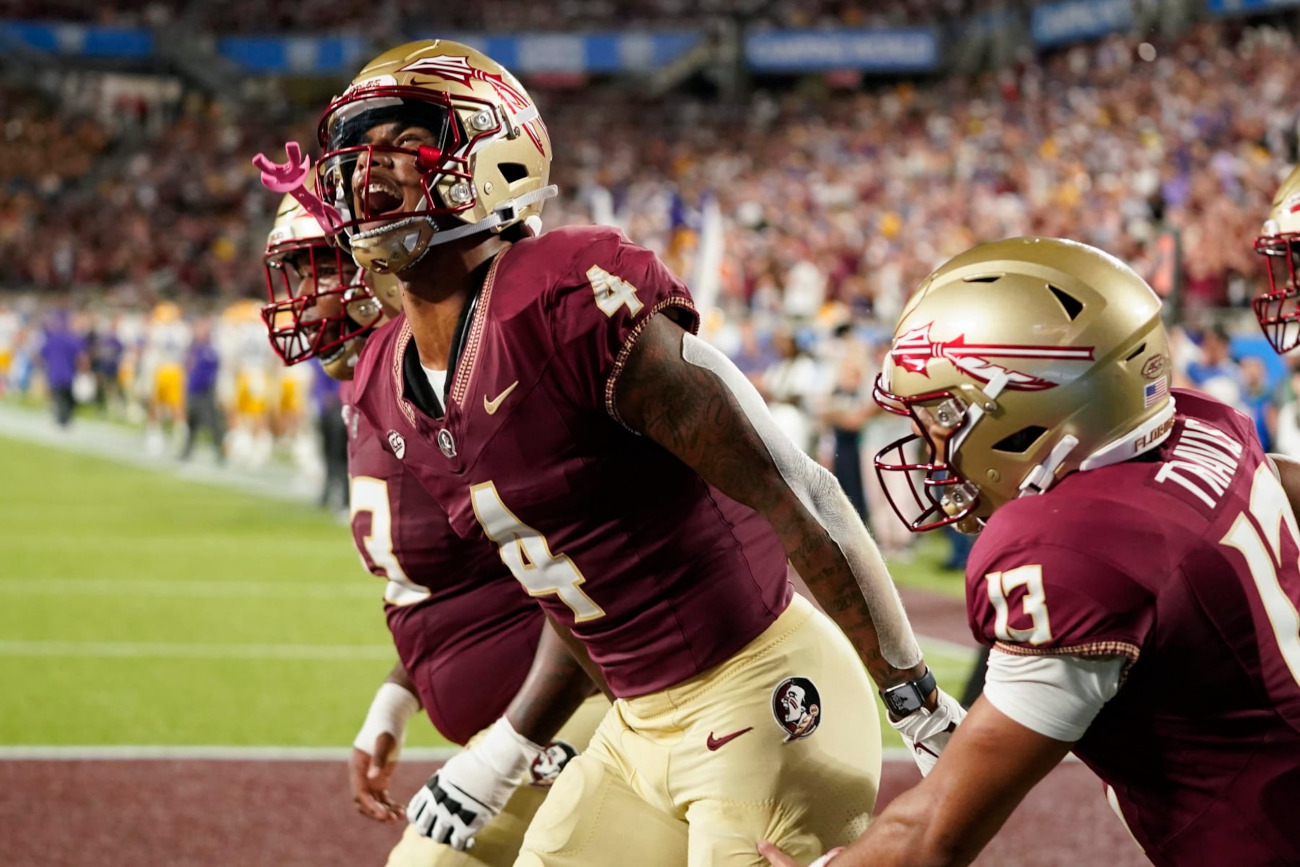Florida State wide receiver Keon Coleman (4) celebrates after scoring a 7-yard touchdown on a pass play from quarterback Jordan Travis (13) during the second half of an NCAA college football game against LSU, Sunday, Sept. 3, 2023, in Orlando, Fla. (AP Photo/John Raoux)