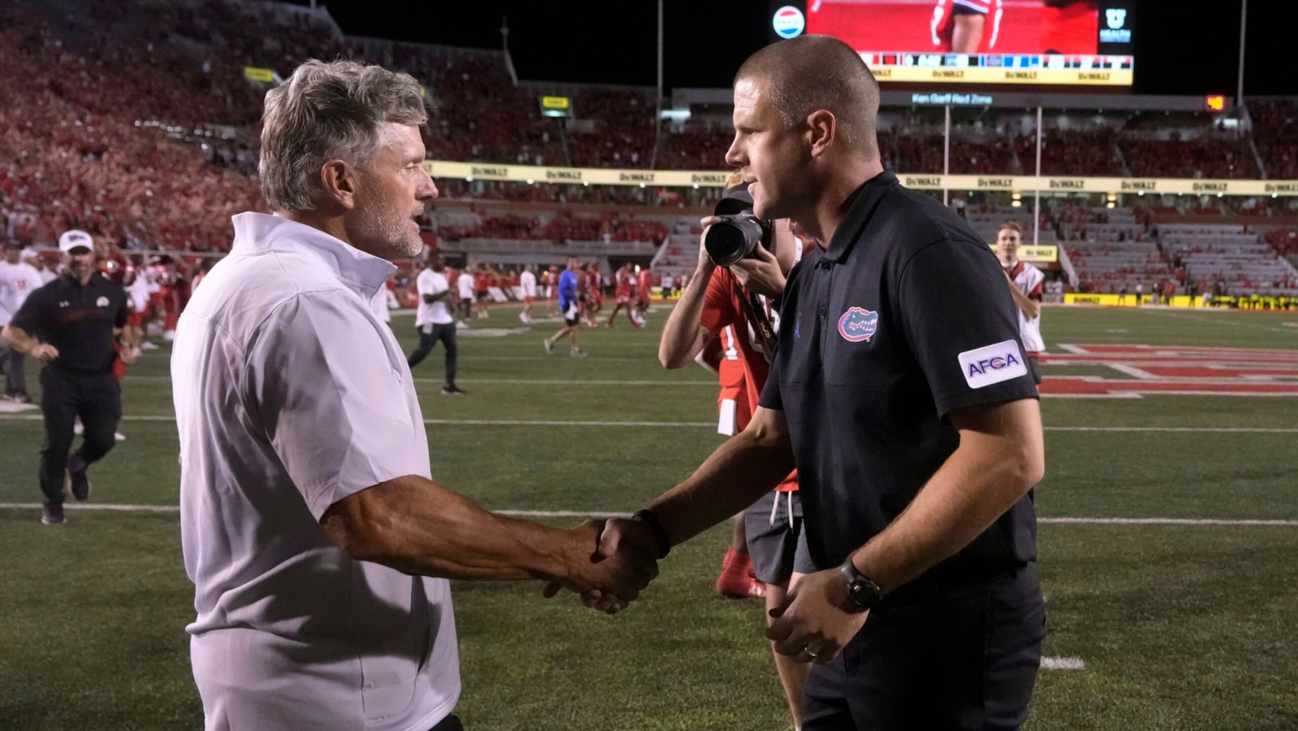 Utah coach Kyle Whittingham, left, and Florida coach Billy Napier shake hands after an NCAA college football game Thursday, Aug. 31, 2023, in Salt Lake City. (AP Photo/Rick Bowmer)