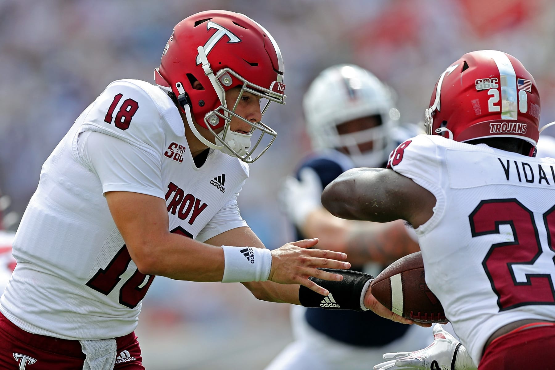 OXFORD, MISSISSIPPI - SEPTEMBER 03: Gunnar Watson #18 of the Troy Trojans hands the ball off to Kimani Vidal #28 of the Troy Trojans during the game against the Mississippi Rebels at Vaught-Hemingway Stadium on September 03, 2022 in Oxford, Mississippi. (Photo by Justin Ford/Getty Images)