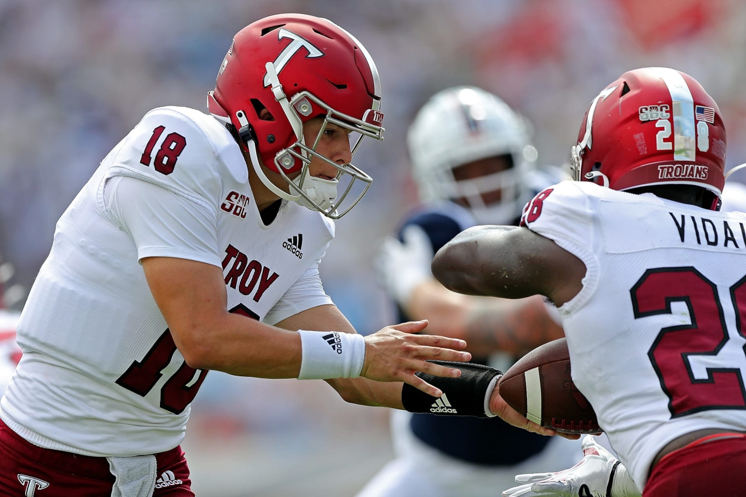OXFORD, MISSISSIPPI - SEPTEMBER 03: Gunnar Watson #18 of the Troy Trojans hands the ball off to Kimani Vidal #28 of the Troy Trojans during the game against the Mississippi Rebels at Vaught-Hemingway Stadium on September 03, 2022 in Oxford, Mississippi. (Photo by Justin Ford/Getty Images)