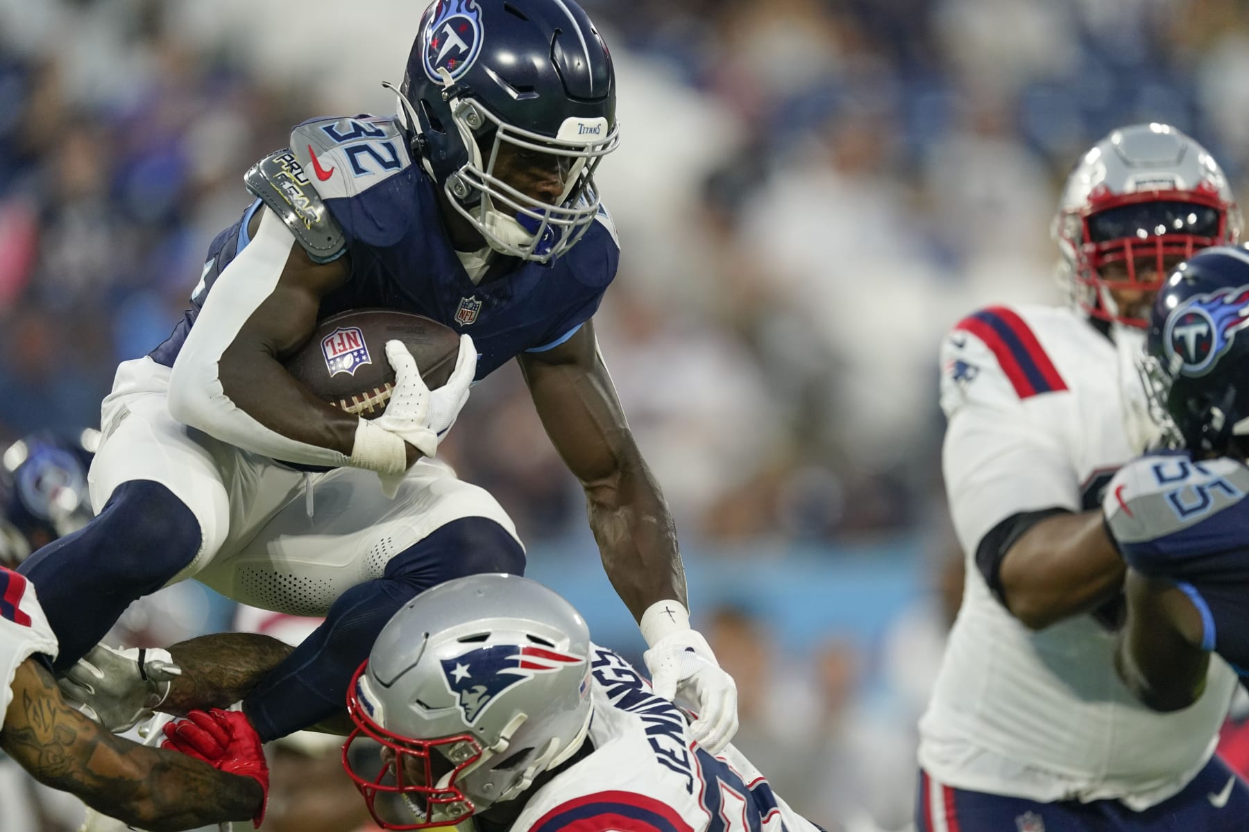 Tennessee Titans running back Tyjae Spears (32) carries over New England Patriots linebacker Anfernee Jennings in the first half of an NFL preseason football game Friday, Aug. 25, 2023, in Nashville, Tenn. (AP Photo/George Walker IV)