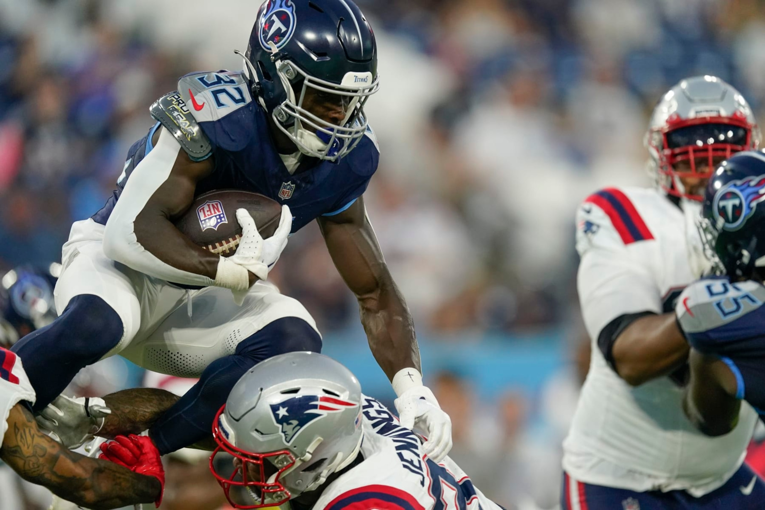 Tennessee Titans running back Tyjae Spears (32) carries over New England Patriots linebacker Anfernee Jennings in the first half of an NFL preseason football game Friday, Aug. 25, 2023, in Nashville, Tenn. (AP Photo/George Walker IV)