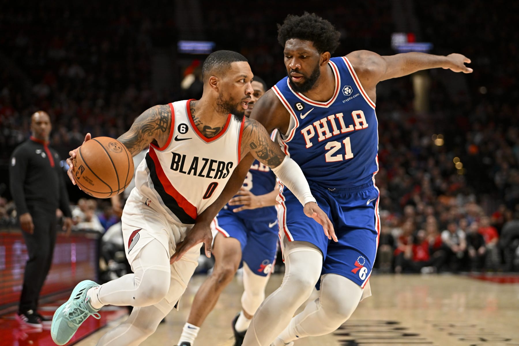 PORTLAND, OREGON - JANUARY 19: Damian Lillard #0 of the Portland Trail Blazers dribbles against Joel Embiid #21 of the Philadelphia 76ers during the second quarter at the Moda Center on January 19, 2023 in Portland, Oregon. NOTE TO USER: User expressly acknowledges and agrees that, by downloading and or using this photograph, User is consenting to the terms and conditions of the Getty Images License Agreement. (Photo by Alika Jenner/Getty Images)