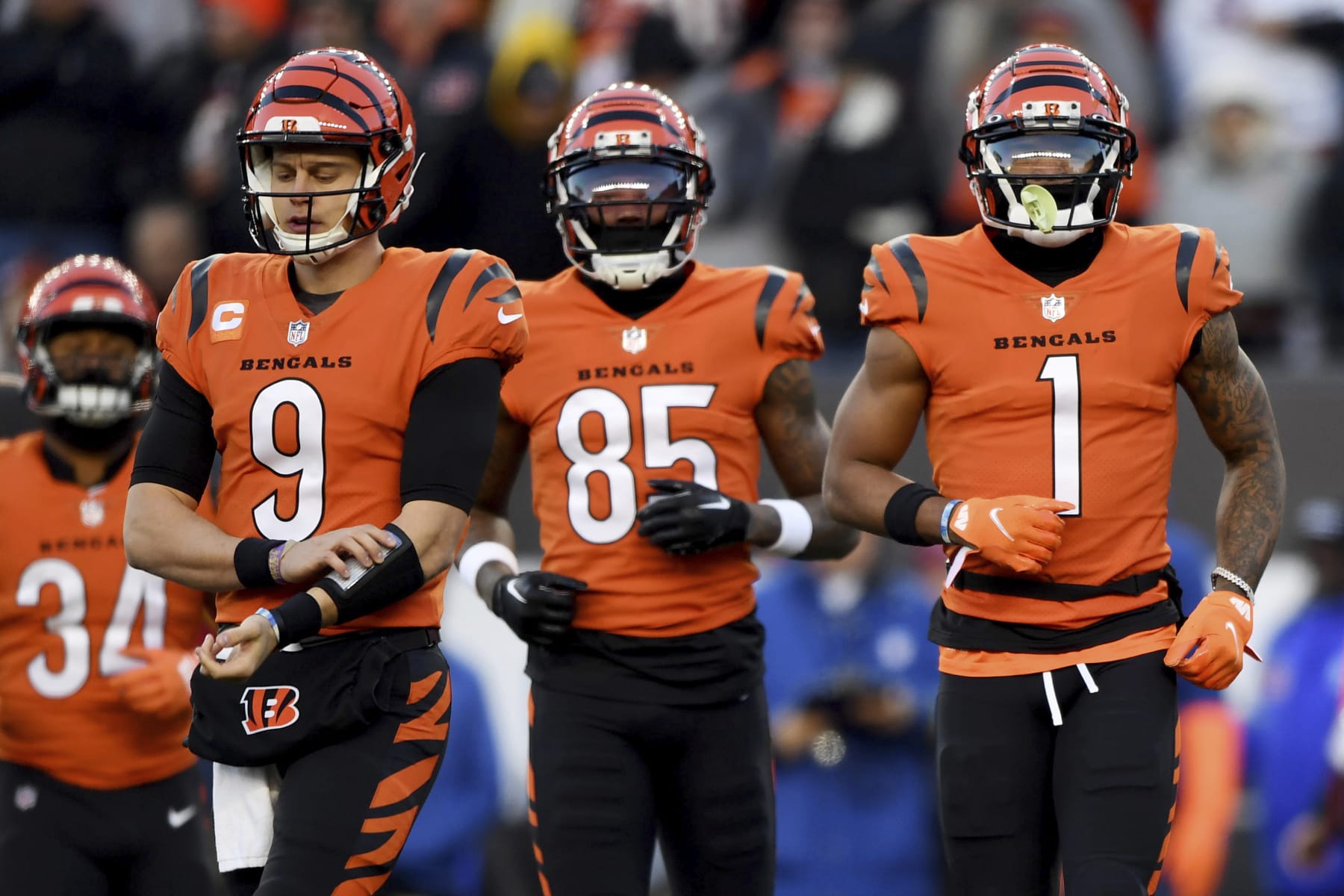 Cincinnati Bengals quarterback Joe Burrow (9), wide receiver Tee Higgins (85) and Cincinnati Bengals wide receiver Ja'Marr Chase (1) run onto the field during an NFL football game against the Kansas City Chiefs, Sunday, Dec. 4, 2022, in Cincinnati. (AP Photo/Emilee Chinn)