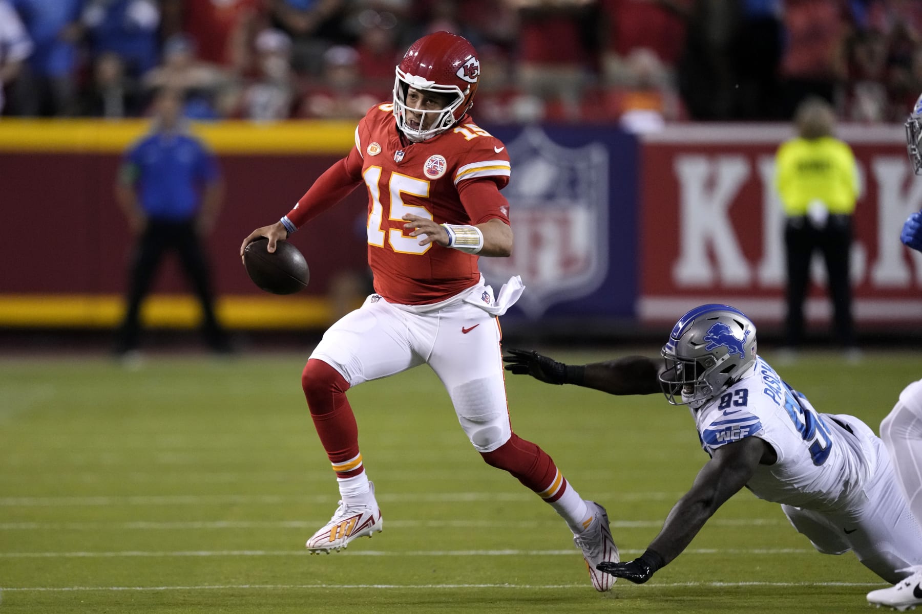 Kansas City Chiefs quarterback Patrick Mahomes (15) scrambles past Detroit Lions defensive end Josh Paschal (93) during the first half of an NFL football game Thursday, Sept. 7, 2023, in Kansas City, Mo. (AP Photo/Charlie Riedel)