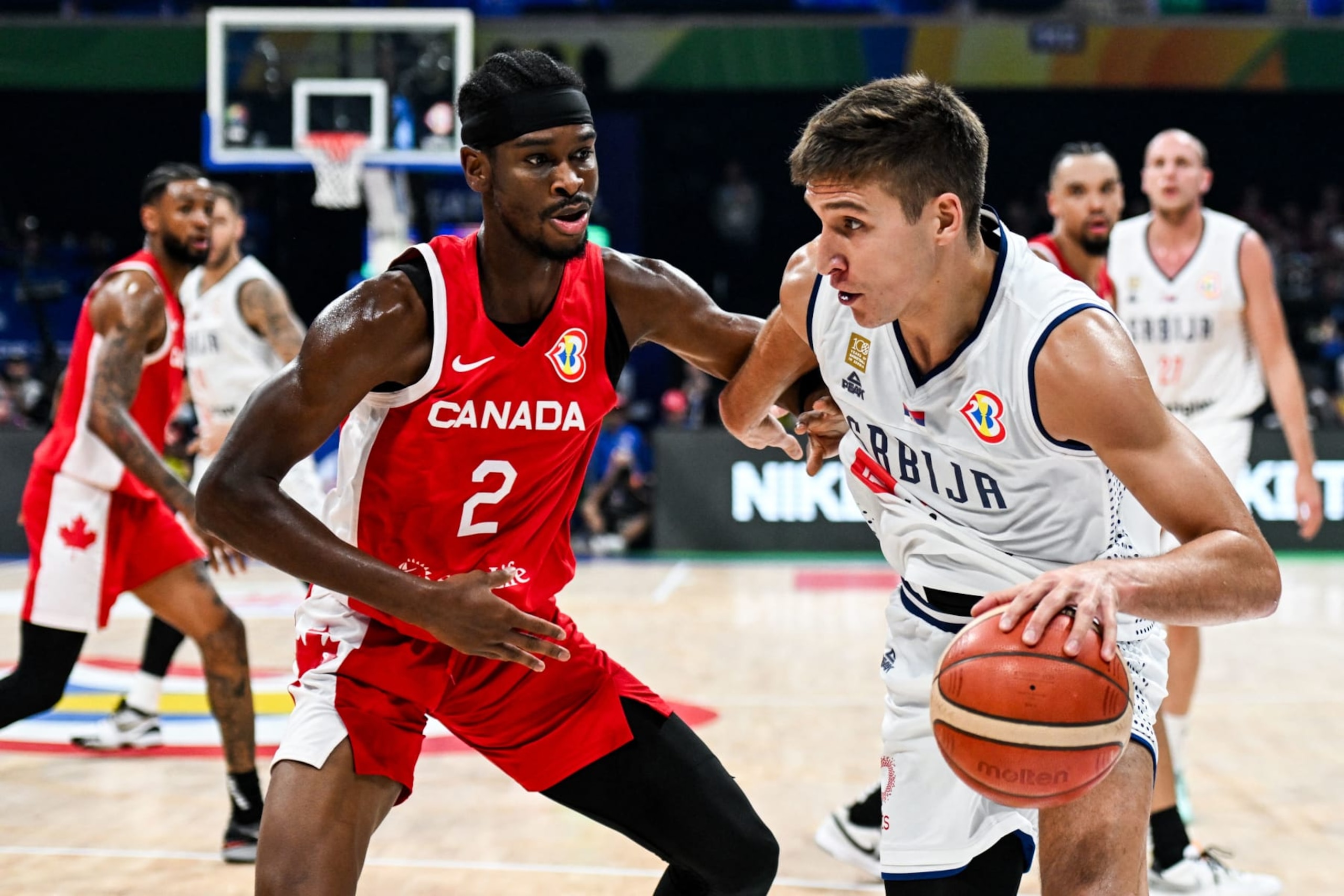 Serbia's Bogdan Bogdanovic (R) blows past Canada's Shai Gilgeous-Alexander (L) during the FIBA Basketball World Cup semi-final match between Serbia and Canada in Manila on September 8, 2023. (Photo by SHERWIN VARDELEON / AFP) (Photo by SHERWIN VARDELEON/AFP via Getty Images)