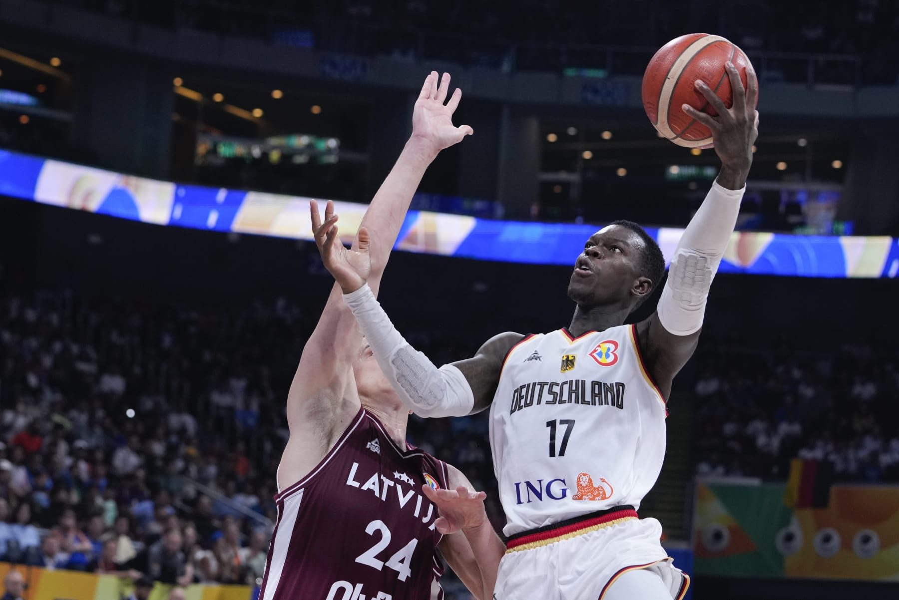 Germany guard Dennis Schroder (17) shoots for goal as Latvia forward Andrejs GraÅ¾ulis (24) attempts to block during the Basketball World Cup quarterfinal between Germany and Latvia in Manila, Philippines, Wednesday, Sept. 6, 2023. (AP Photo/Michael Conroy)