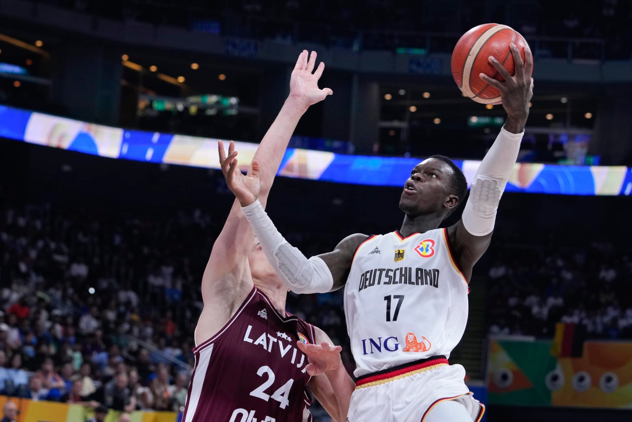 Germany guard Dennis Schroder (17) shoots for goal as Latvia forward Andrejs GraÅ¾ulis (24) attempts to block during the Basketball World Cup quarterfinal between Germany and Latvia in Manila, Philippines, Wednesday, Sept. 6, 2023. (AP Photo/Michael Conroy)