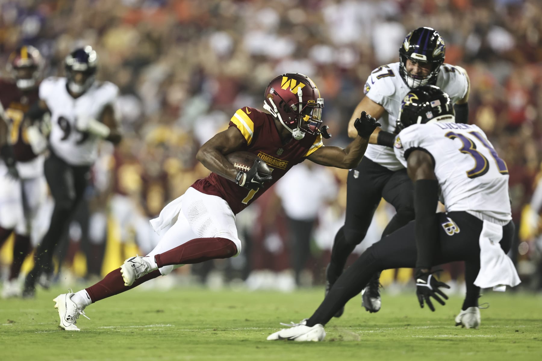 LANDOVER, MARYLAND - AUGUST 21: Jahan Dotson #1 of the Washington Commanders runs with the ball against Jeremy Lucien #31 of the Baltimore Ravens during an NFL preseason game at FedExField on August 21, 2023 in Landover, Maryland. (Photo by Michael Owens/Getty Images) LANDOVER, MARYLAND - AUGUST 21: Jahan Dotson #1 of the Washington Commanders runs with the ball against Jeremy Lucien #31 of the Baltimore Ravens during an NFL preseason game at FedExField on August 21, 2023 in Landover, Maryland. (Photo by Michael Owens/Getty Images)