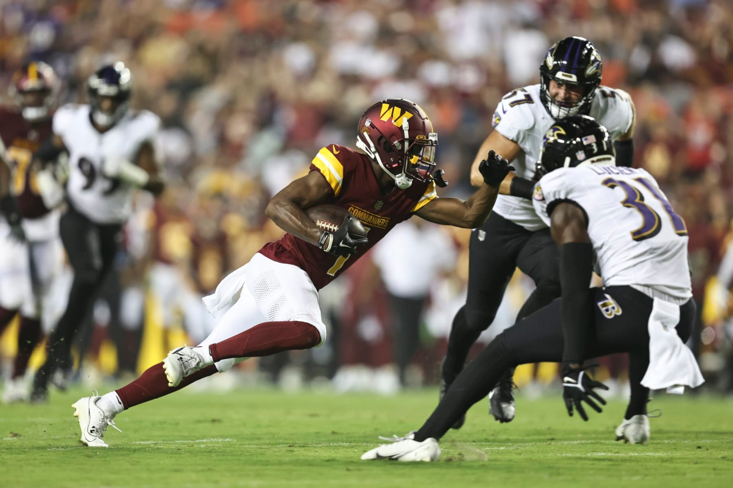 LANDOVER, MARYLAND - AUGUST 21: Jahan Dotson #1 of the Washington Commanders runs with the ball against Jeremy Lucien #31 of the Baltimore Ravens during an NFL preseason game at FedExField on August 21, 2023 in Landover, Maryland. (Photo by Michael Owens/Getty Images)