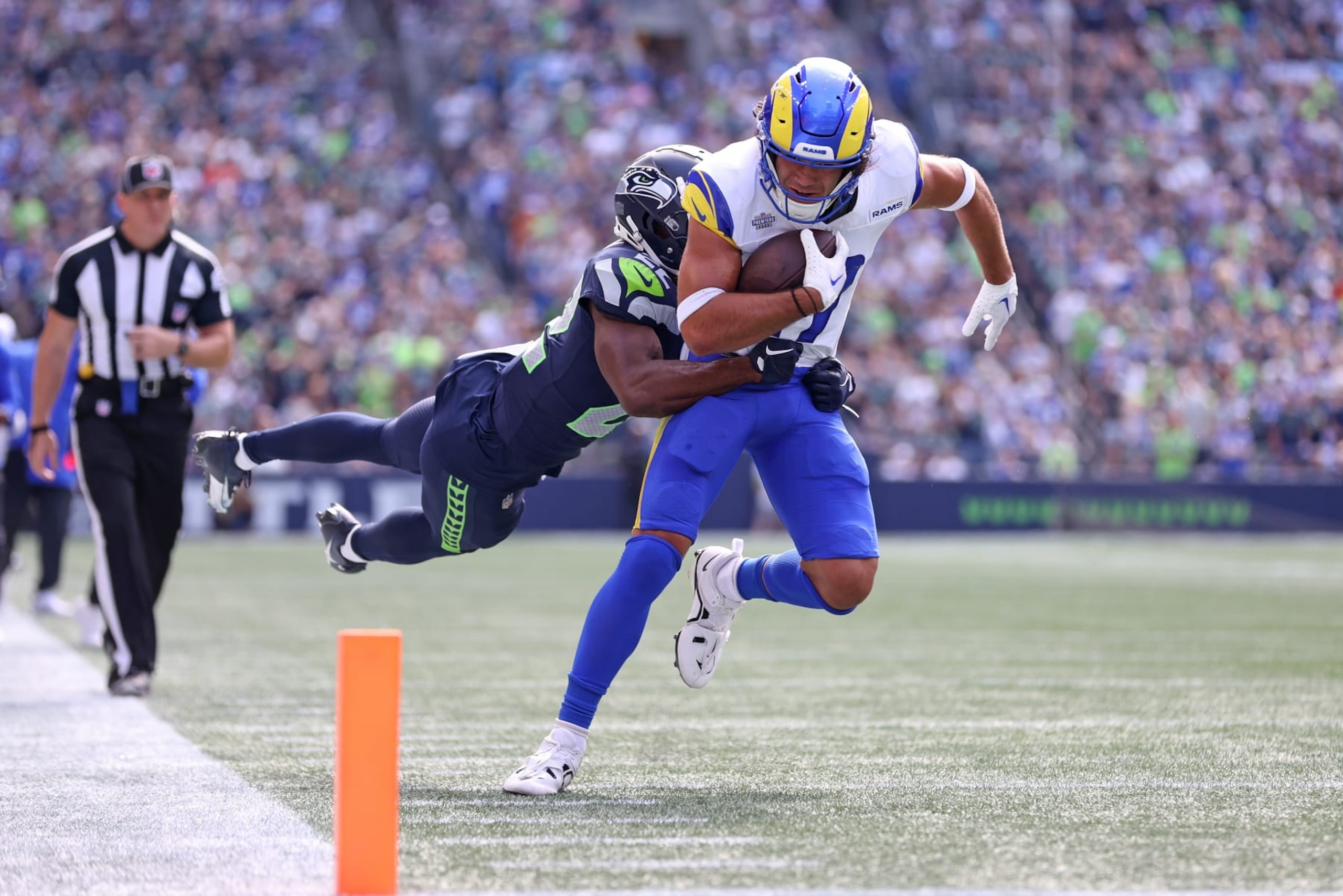 SEATTLE, WASHINGTON - SEPTEMBER 10:  Puka Nacua #17 of the Los Angeles Rams is tackled by Tre Brown #22 of the Seattle Seahawks after a reception during the first half at Lumen Field on September 10, 2023 in Seattle, Washington. (Photo by Steph Chambers/Getty Images)