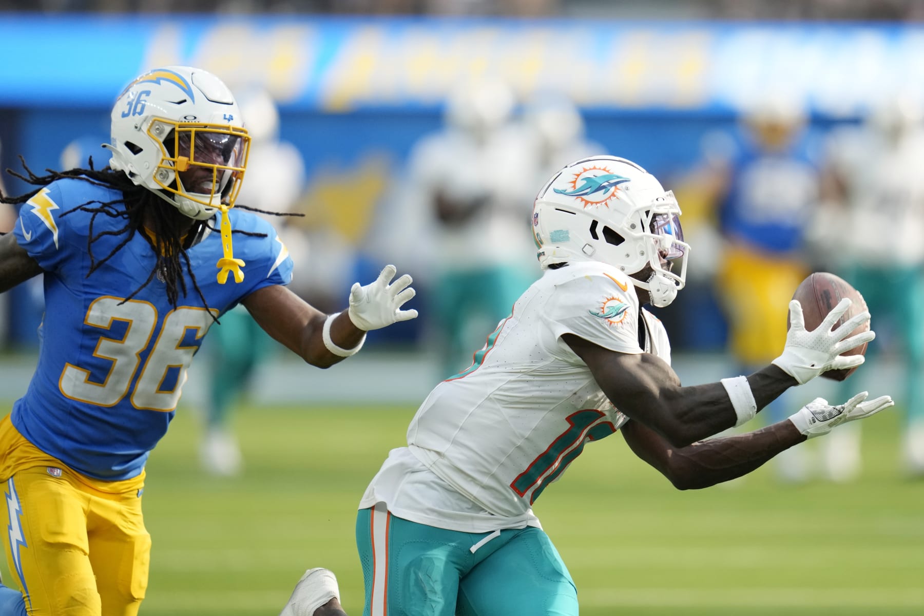Miami Dolphins wide receiver Tyreek Hill (10) makes a catch in front of Los Angeles Chargers cornerback Ja'Sir Taylor during the second half of an NFL football game Sunday, Sept. 10, 2023, in Inglewood, Calif. (AP Photo/Ashley Landis)