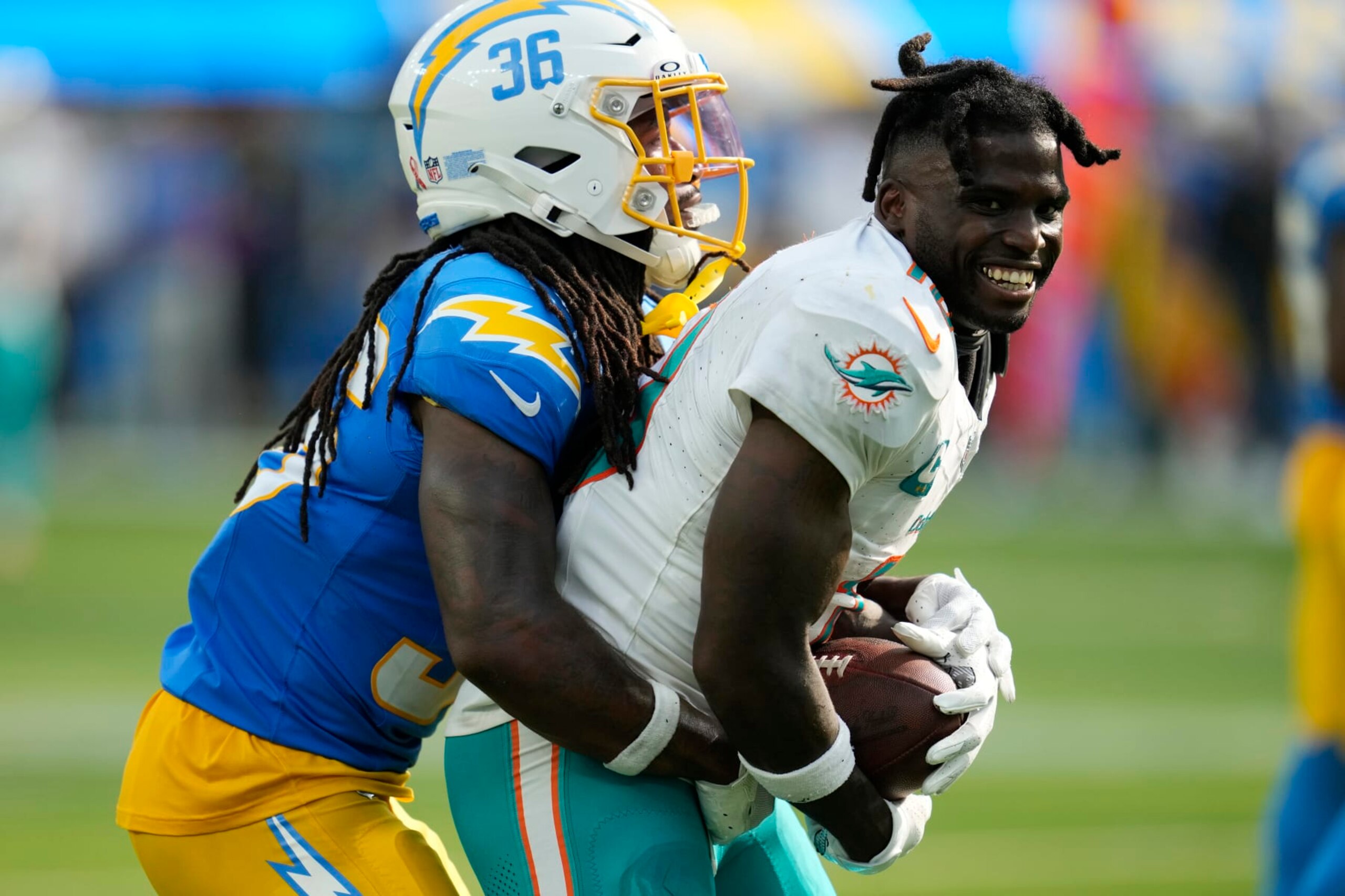 Miami Dolphins wide receiver Tyreek Hill (10) loses his helmet after making a catch next to Los Angeles Chargers cornerback Ja'Sir Taylor during the second half of an NFL football game Sunday, Sept. 10, 2023, in Inglewood, Calif. (AP Photo/Ashley Landis) Miami Dolphins wide receiver Tyreek Hill (10) loses his helmet after making a catch next to Los Angeles Chargers cornerback Ja'Sir Taylor during the second half of an NFL football game Sunday, Sept. 10, 2023, in Inglewood, Calif. (AP Photo/Ashley Landis)