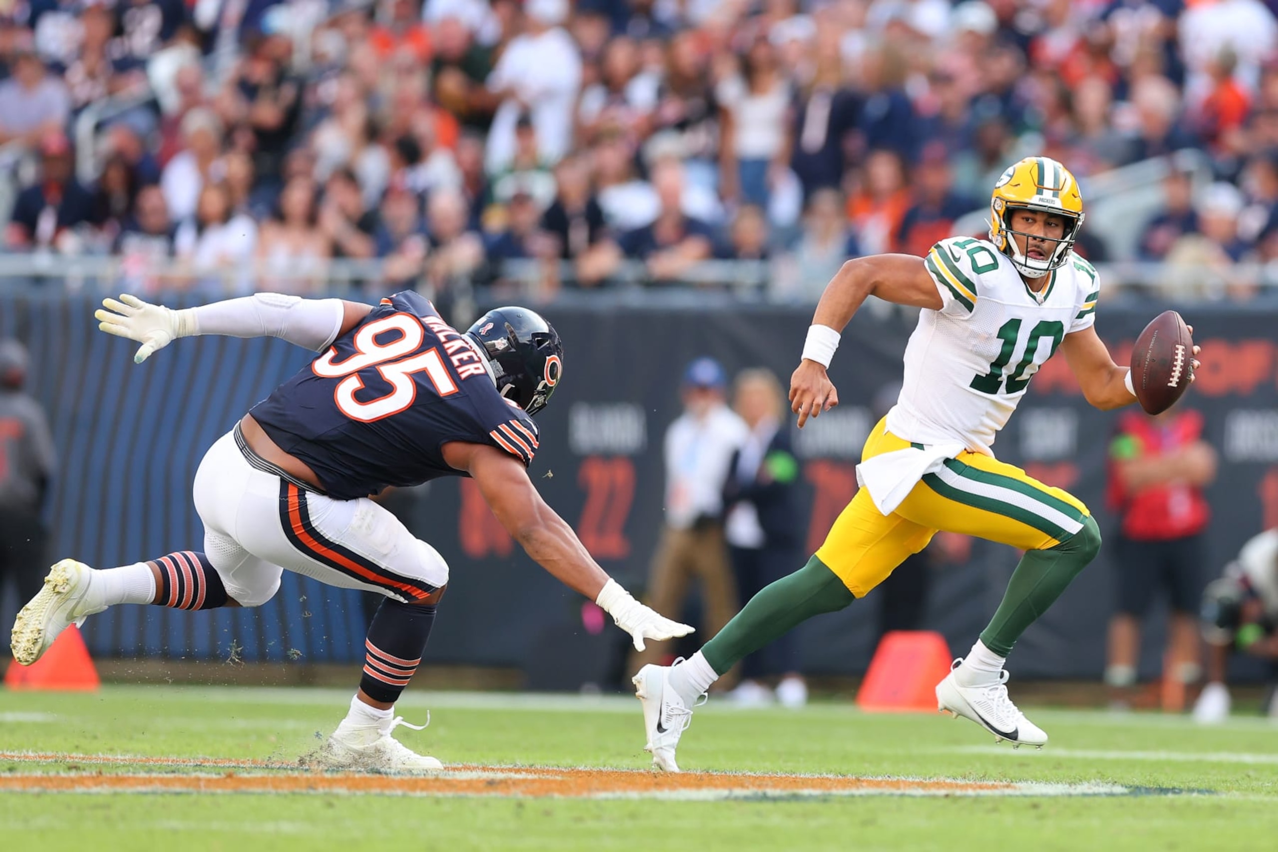 CHICAGO, ILLINOIS - SEPTEMBER 10:  Jordan Love #10 of the Green Bay Packers scrambles away from DeMarcus Walker #95 of the Chicago Bears during the second half at Soldier Field on September 10, 2023 in Chicago, Illinois. (Photo by Michael Reaves/Getty Images)