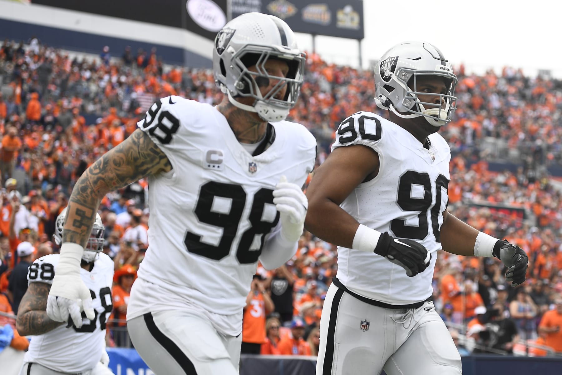 DENVER, COLORADO - SEPTEMBER 10: Maxx Crosby #98 of the Las Vegas Raiders and Jerry Tillery #90 of the Las Vegas Raiders run onto the field before their game against the Denver Broncos at Empower Field At Mile High on September 10, 2023 in Denver, Colorado. (Photo by Dustin Bradford/Getty Images)