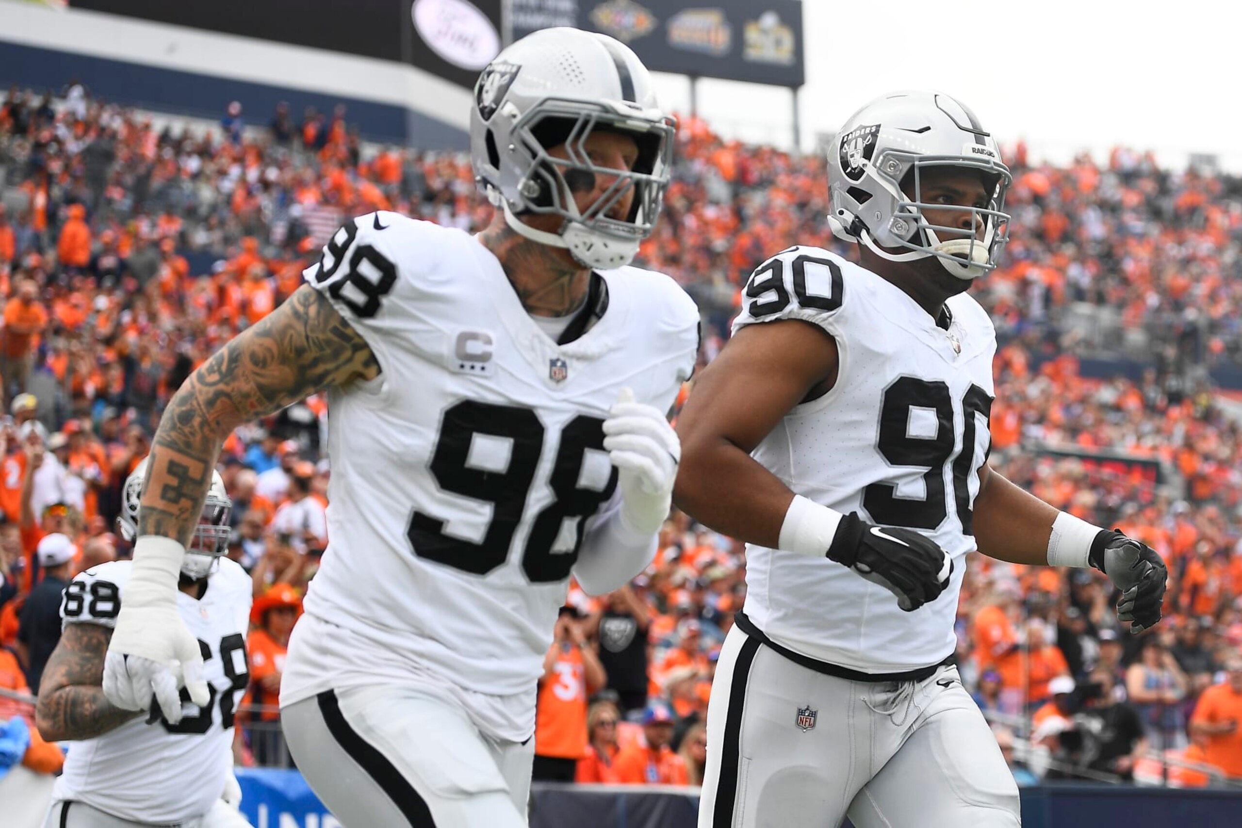 DENVER, COLORADO - SEPTEMBER 10: Maxx Crosby #98 of the Las Vegas Raiders and Jerry Tillery #90 of the Las Vegas Raiders run onto the field before their game against the Denver Broncos at Empower Field At Mile High on September 10, 2023 in Denver, Colorado. (Photo by Dustin Bradford/Getty Images)