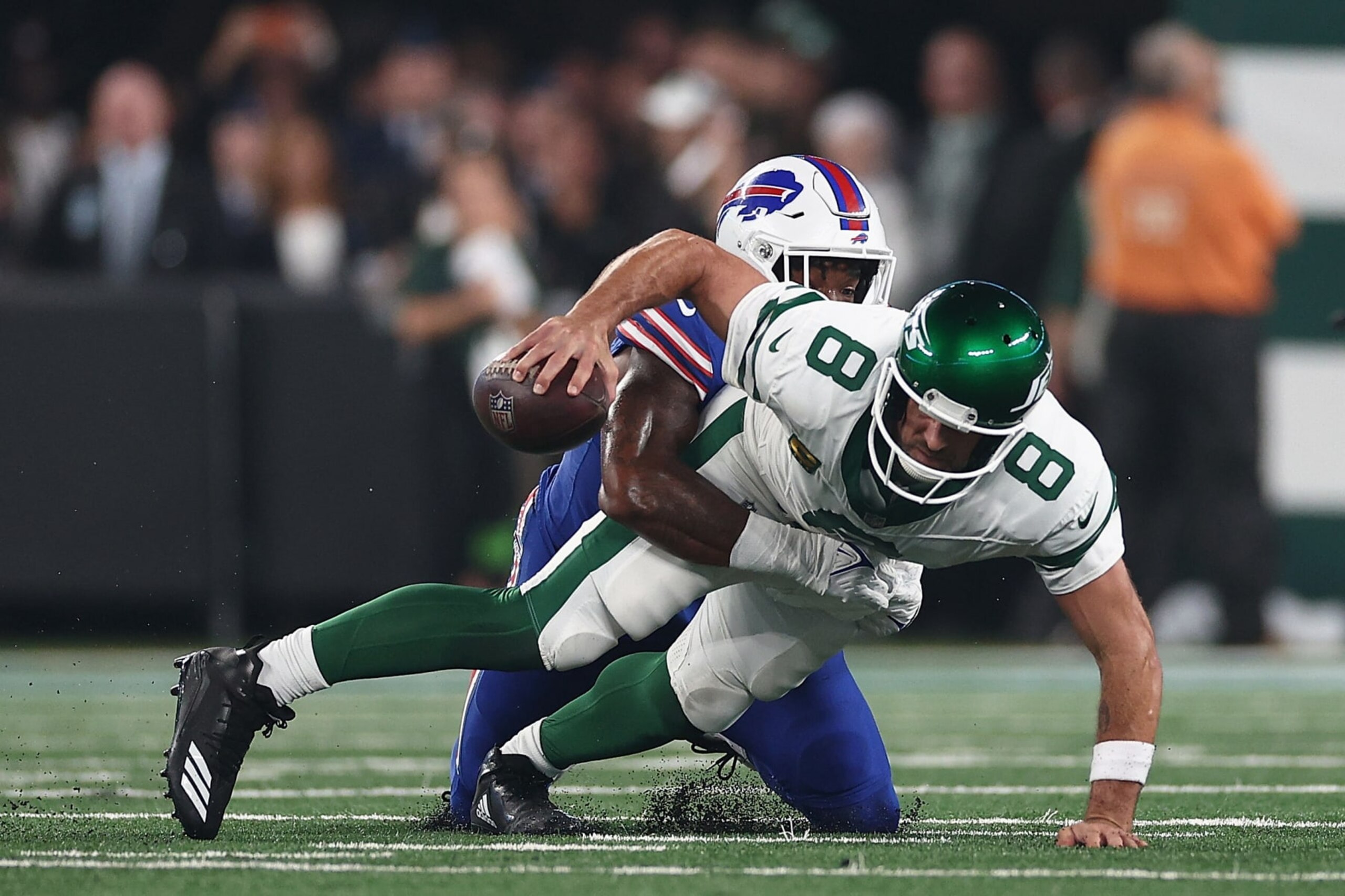 EAST RUTHERFORD, NEW JERSEY - SEPTEMBER 11: Quarterback Aaron Rodgers #8 of the New York Jets sacked by defensive end Leonard Floyd #56 of the Buffalo Bills during the first quarter of the NFL game at MetLife Stadium on September 11, 2023 in East Rutherford, New Jersey. (Photo by Elsa/Getty Images)