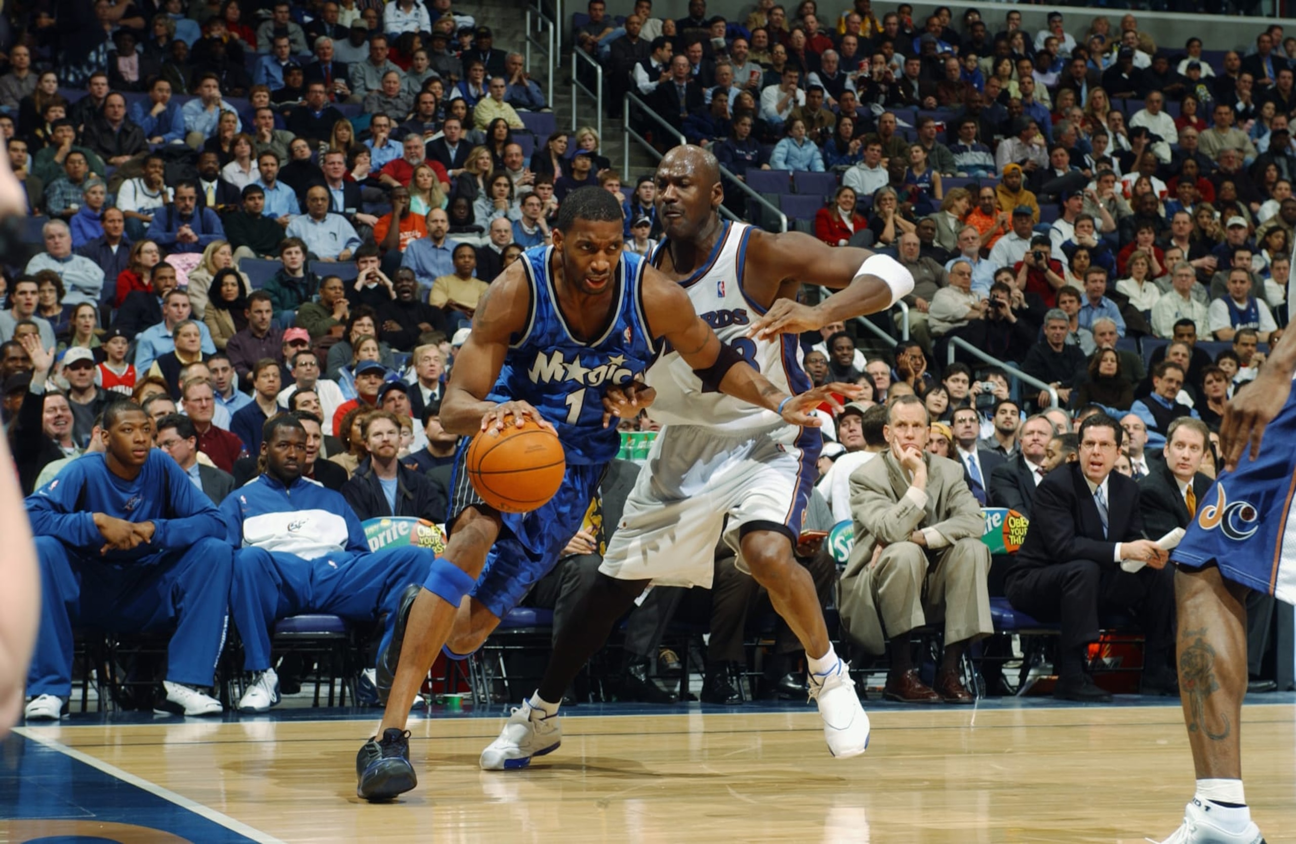 WASHINGTON - MARCH 11:  Tracy McGrady #1 of the Orlando Magic drives around Michael Jordan #23 of the Washington Wizards during the game at MCI Center on March 11, 2003 in Washington, D.C.  The Wizards won 106-105.  NOTE TO USER: User expressly acknowledges and agrees that, by downloading and/or using this Photograph, User is consenting to the terms and conditions of the Getty Images License Agreement.  Copyright 2003 NBAE  (Photo by Mitchell Layton/NBAE via Getty Images)