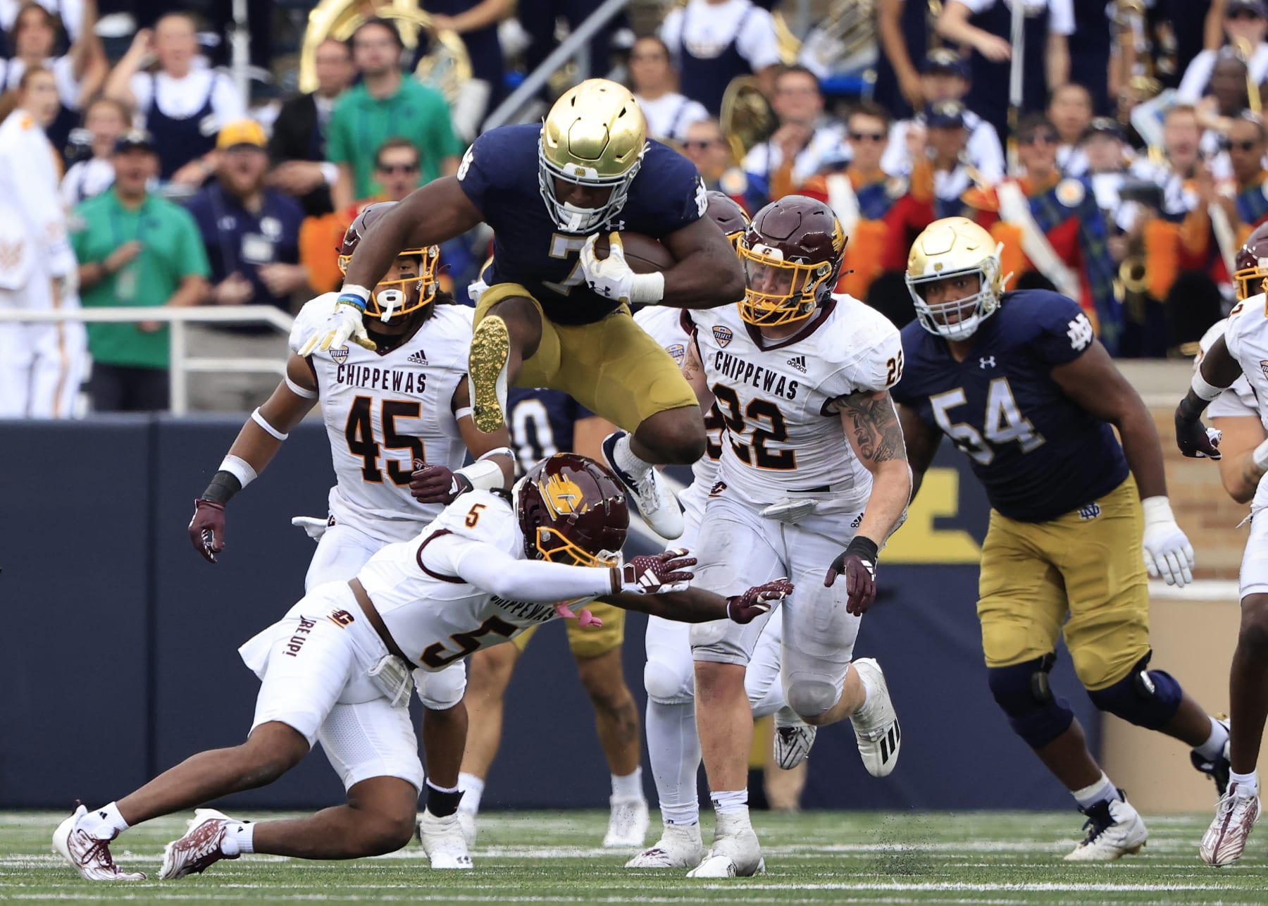 SOUTH BEND, INDIANA - SEPTEMBER 16: Audric Estime #7 of the Notre Dame Fighting Irish huddles over De'Javion Stepney #5 of the Central Michigan Chippewas during the second half at Notre Dame Stadium on September 16, 2023 in South Bend, Indiana. (Photo by Justin Casterline/Getty Images)