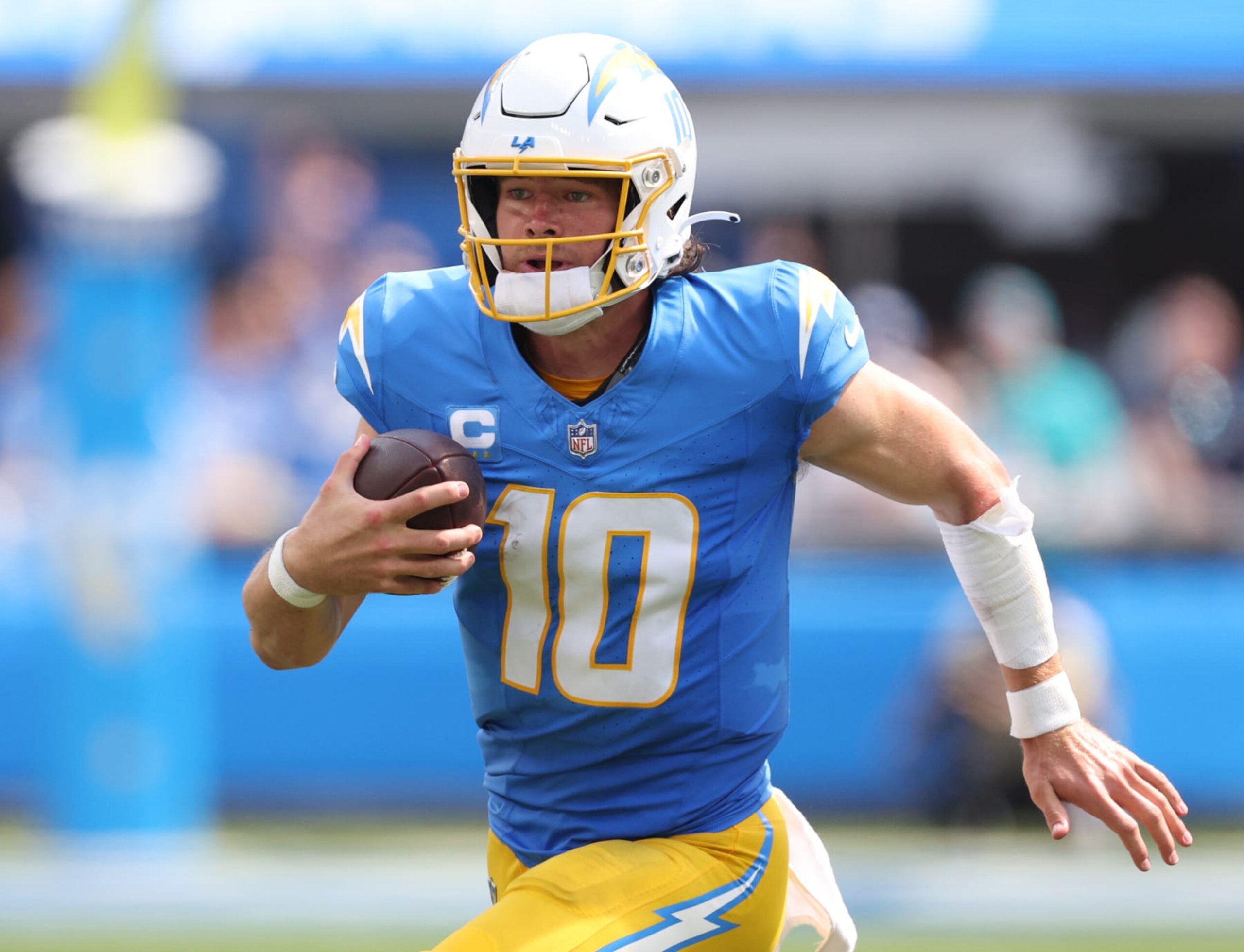 INGLEWOOD, CALIFORNIA - SEPTEMBER 10: Justin Herbert #10 of the Los Angeles Chargers scrambles out of the pocket during a 36-34 loss to the Miami Dolphins at SoFi Stadium on September 10, 2023 in Inglewood, California. (Photo by Harry How/Getty Images)