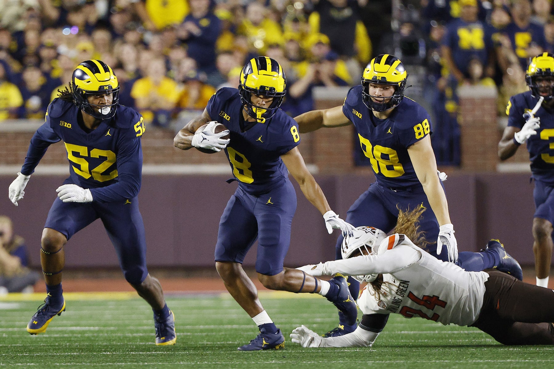 ANN ARBOR, MICHIGAN - SEPTEMBER 16: Tyler Morris #8 of the Michigan Wolverines breaks a tackle by Diego Neri #24 of the Bowling Green Falcons in the first quarter of a game  at Michigan Stadium on September 16, 2023 in Ann Arbor, Michigan. (Photo by Mike Mulholland/Getty Images)