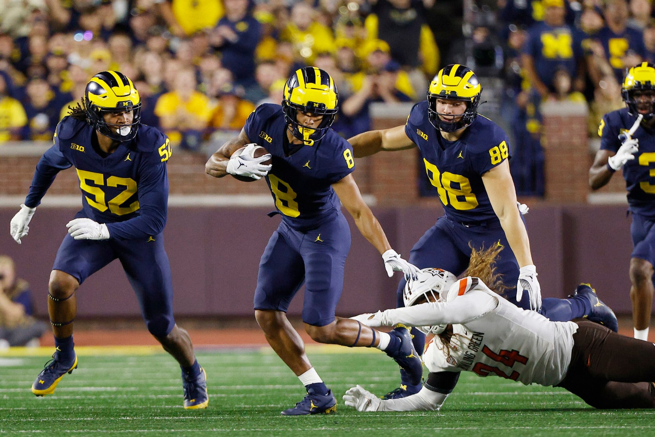 ANN ARBOR, MICHIGAN - SEPTEMBER 16: Tyler Morris #8 of the Michigan Wolverines breaks a tackle by Diego Neri #24 of the Bowling Green Falcons in the first quarter of a game  at Michigan Stadium on September 16, 2023 in Ann Arbor, Michigan. (Photo by Mike Mulholland/Getty Images)
