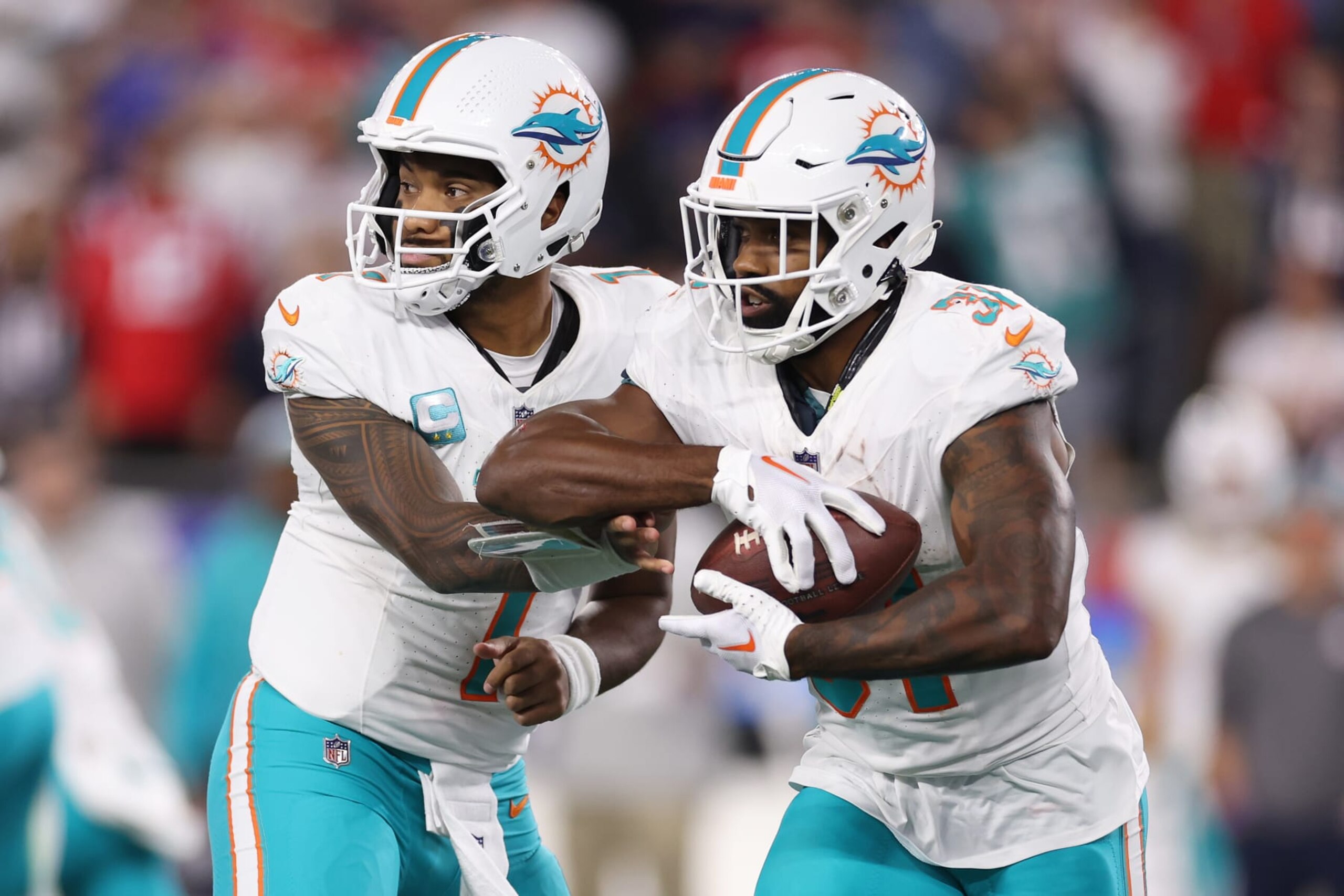 FOXBOROUGH, MASSACHUSETTS - SEPTEMBER 17: Tua Tagovailoa #1 of the Miami Dolphins hands the ball to Raheem Mostert #31 during the second quarter against the New England Patriots at Gillette Stadium on September 17, 2023 in Foxborough, Massachusetts. (Photo by Maddie Meyer/Getty Images)
