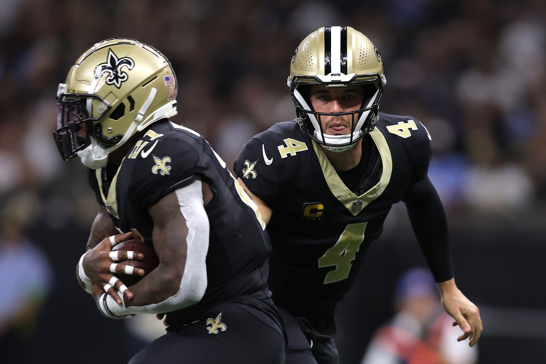 NEW ORLEANS, LOUISIANA - SEPTEMBER 10: Derek Carr #4 of the New Orleans Saints hands the ball to Jamaal Williams #21 during the second quarter against the Tennessee Titans at Caesars Superdome on September 10, 2023 in New Orleans, Louisiana. (Photo by Jonathan Bachman/Getty Images)