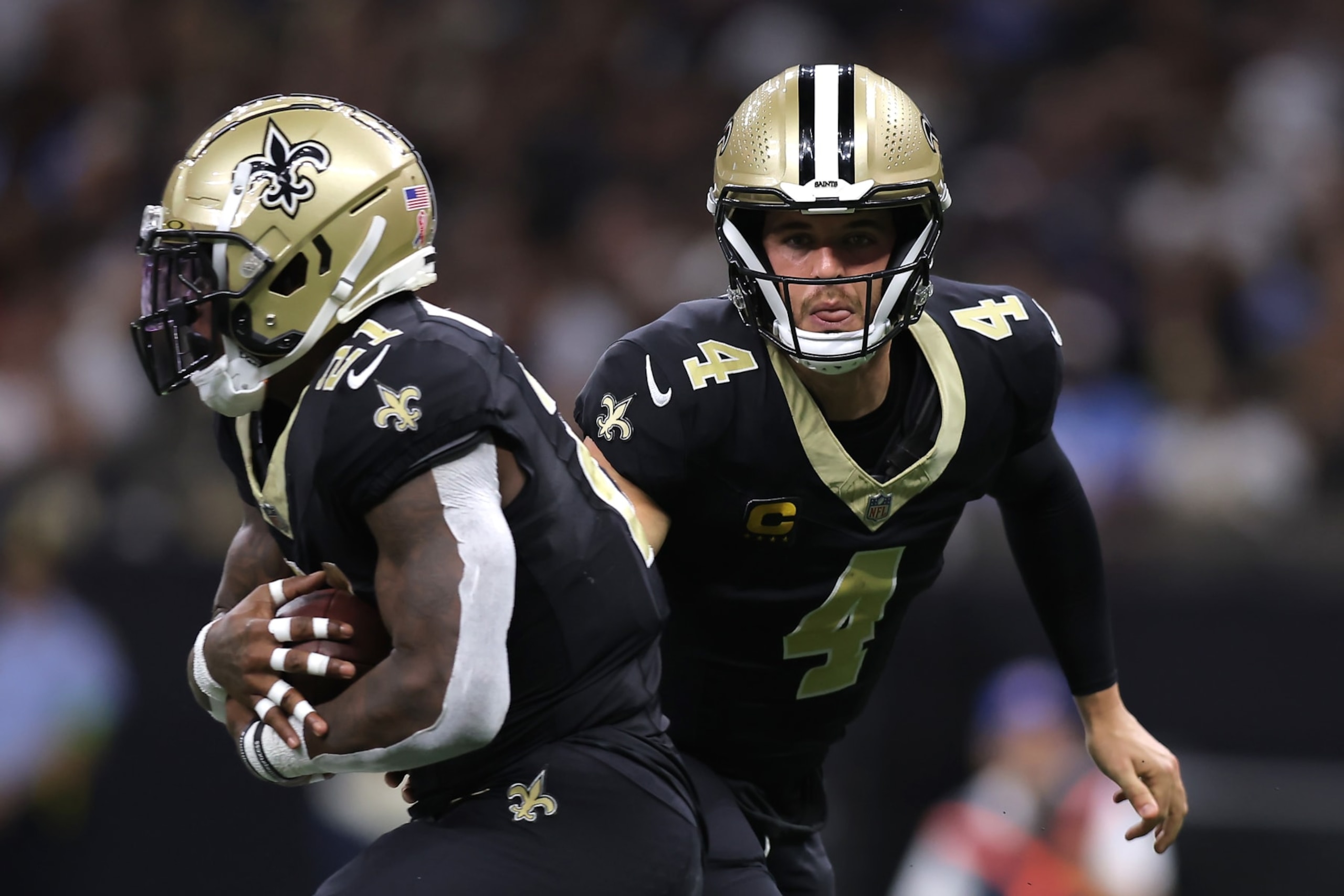 NEW ORLEANS, LOUISIANA - SEPTEMBER 10: Derek Carr #4 of the New Orleans Saints hands the ball to Jamaal Williams #21 during the second quarter against the Tennessee Titans at Caesars Superdome on September 10, 2023 in New Orleans, Louisiana. (Photo by Jonathan Bachman/Getty Images)