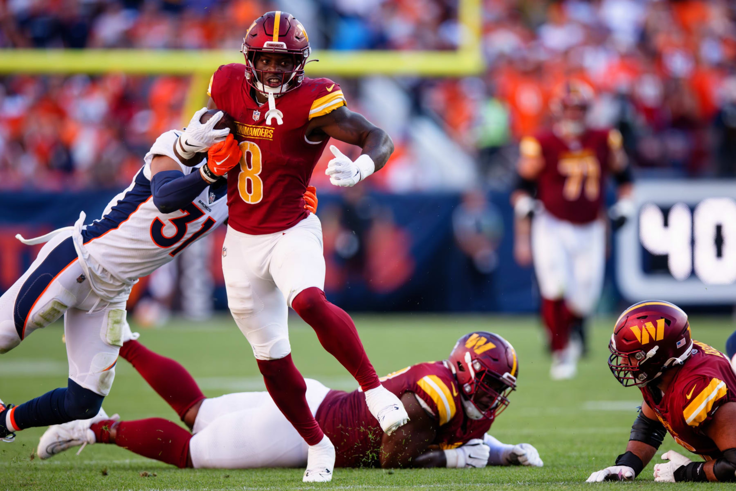 DENVER, CO - SEPTEMBER 17:  Running back Brian Robinson Jr. #8 of the Washington Commanders runs with the football during the fourth quarter against the Denver Broncos at Empower Field at Mile High on September 17, 2023 in Denver, Colorado. (Photo by Justin Edmonds/Getty Images)
