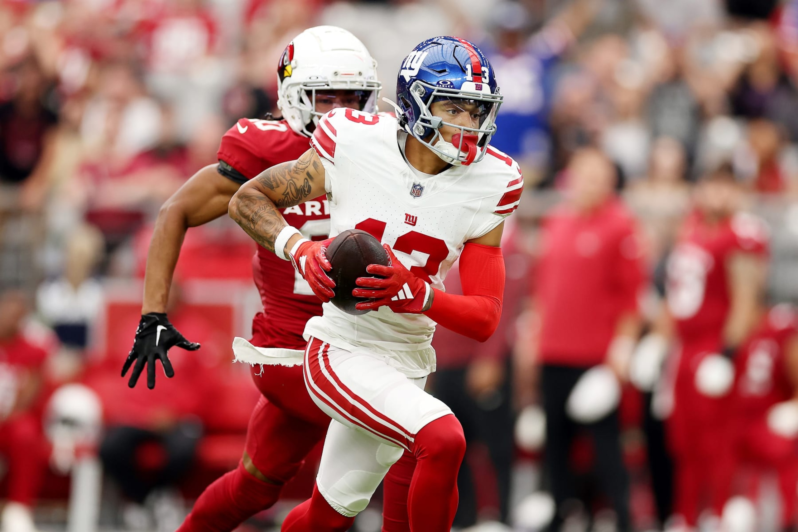 GLENDALE, ARIZONA - SEPTEMBER 17: Jalin Hyatt #13 of the New York Giants catches a pass while being chased by Marco Wilson #20 of the Arizona Cardinals during the third quarter at State Farm Stadium on September 17, 2023 in Glendale, Arizona. (Photo by Christian Petersen/Getty Images)