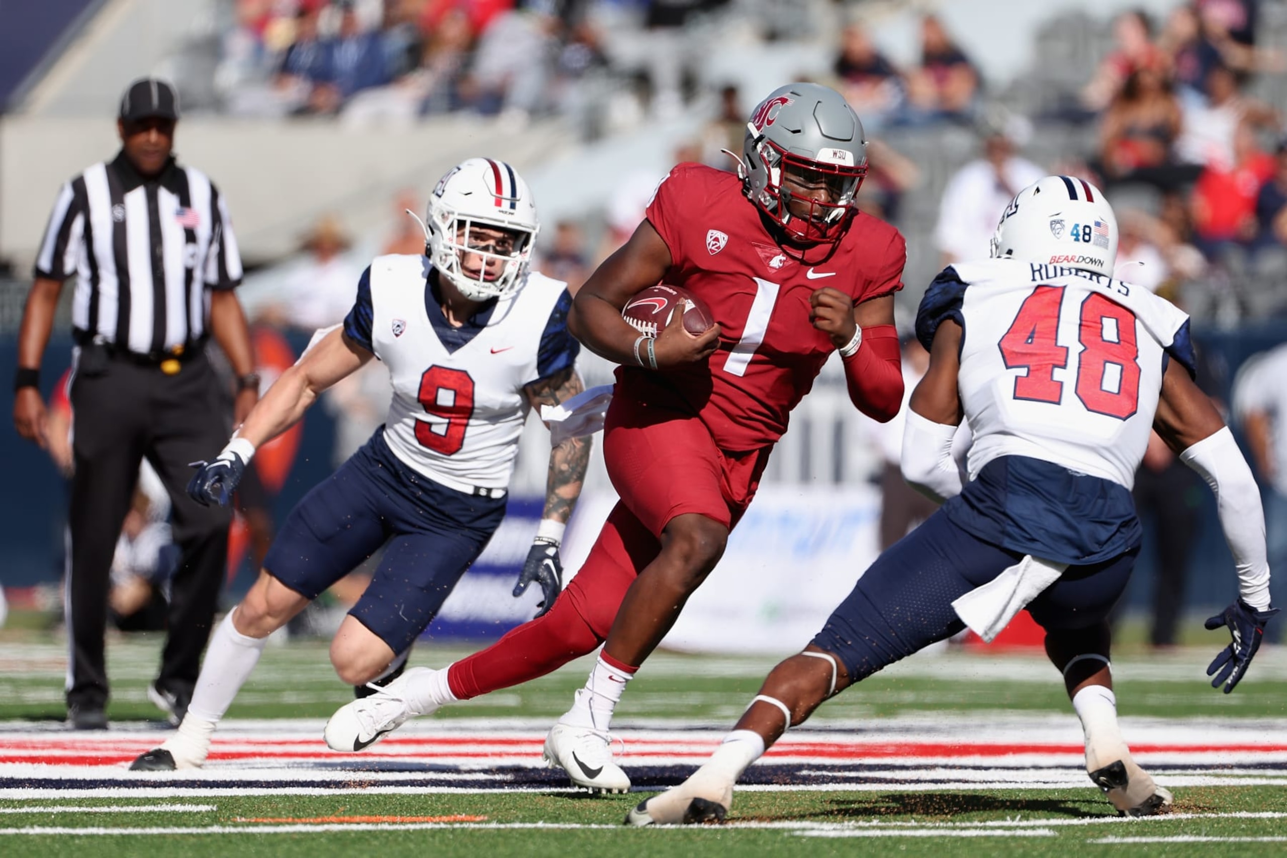 TUCSON, ARIZONA - NOVEMBER 19: Quarterback Cameron Ward #1 of the Washington State Cougars scrambles with the football against linebacker Jerry Roberts #48 and safety Gunner Maldonado #9 of the Arizona Wildcats during the second half of the NCAAF game at Arizona Stadium on November 19, 2022 in Tucson, Arizona. (Photo by Christian Petersen/Getty Images)
