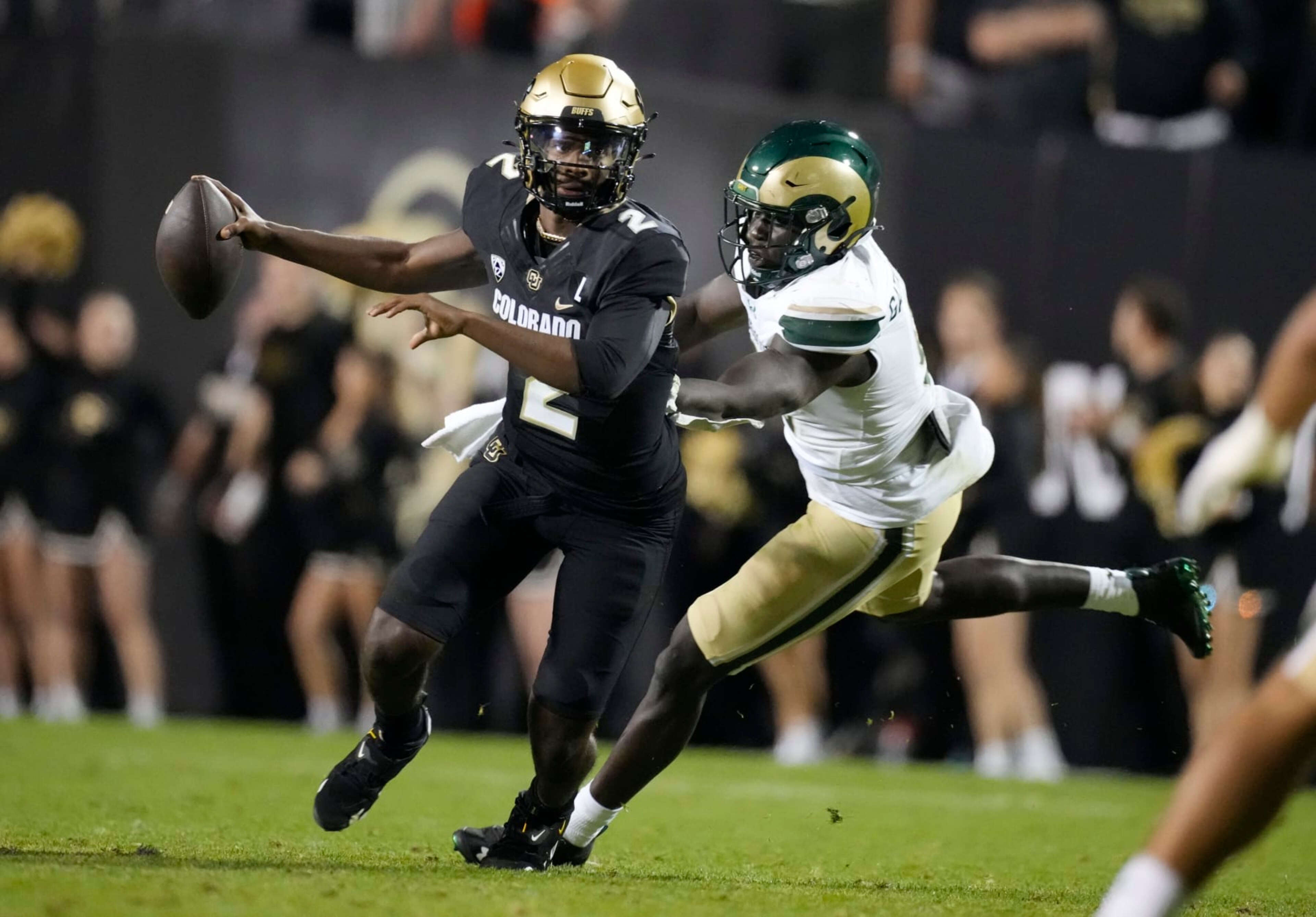 Colorado quarterback Shedeur Sanders, left, eludes a tackle by Colorado State defensive lineman Nuer Gatkuoth in the second half of an NCAA college football game Saturday, Sept. 16, 2023, in Boulder, Colo. (AP Photo/David Zalubowski) Colorado quarterback Shedeur Sanders, left, eludes a tackle by Colorado State defensive lineman Nuer Gatkuoth in the second half of an NCAA college football game Saturday, Sept. 16, 2023, in Boulder, Colo. (AP Photo/David Zalubowski)