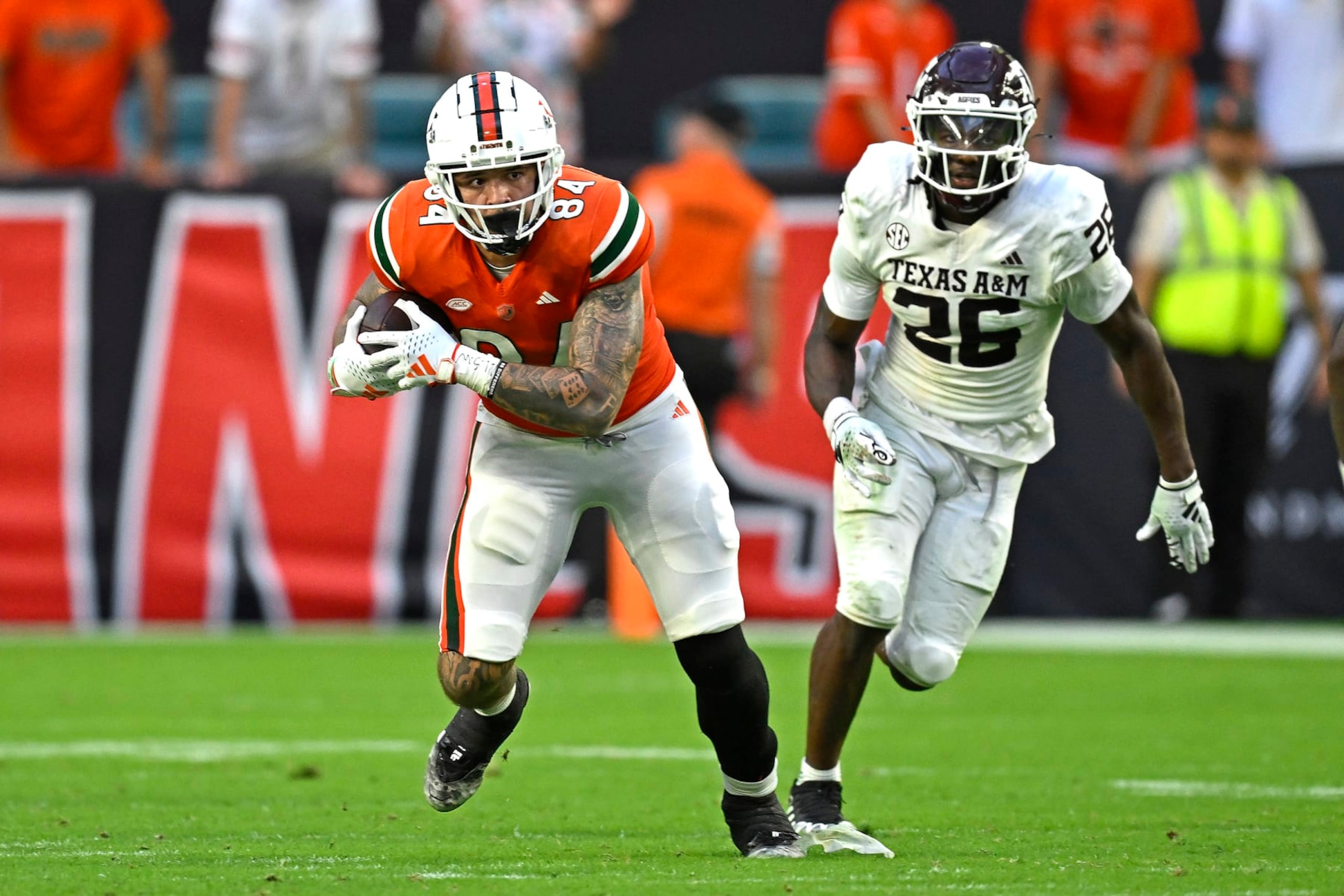 MIAMI GARDENS, FL - SEPTEMBER 09: Miami tight end Cam McCormick (84) takes a reception 20 yards while pursued by Texas A&M defensive back Demani Richardson (26) in the fourth quarter as the Miami Hurricanes faced the Texas A&M Aggies on September 9, 2023, at Hard Rock Stadium in Miami Gardens, Florida. (Photo by Samuel Lewis/Icon Sportswire via Getty Images) MIAMI GARDENS, FL - SEPTEMBER 09: Miami tight end Cam McCormick (84) takes a reception 20 yards while pursued by Texas A&M defensive back Demani Richardson (26) in the fourth quarter as the Miami Hurricanes faced the Texas A&M Aggies on September 9, 2023, at Hard Rock Stadium in Miami Gardens, Florida. (Photo by Samuel Lewis/Icon Sportswire via Getty Images)