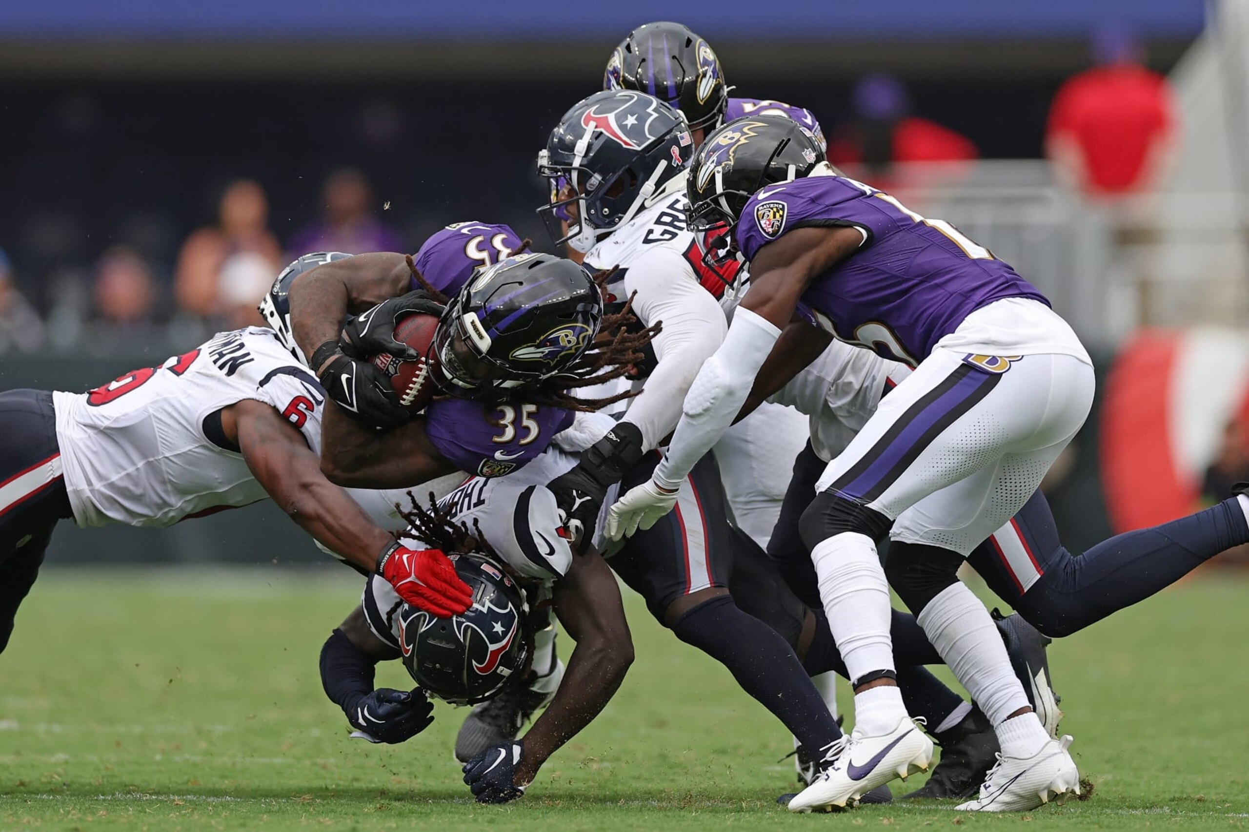 BALTIMORE, MARYLAND - SEPTEMBER 10:  Gus Edwards #35 of the Baltimore Ravens is tackled by Denzel Perryman #6 and Jonathan Greenard #52 of the Houston Texans during the second half at M&T Bank Stadium on September 10, 2023 in Baltimore, Maryland. (Photo by Patrick Smith/Getty Images)